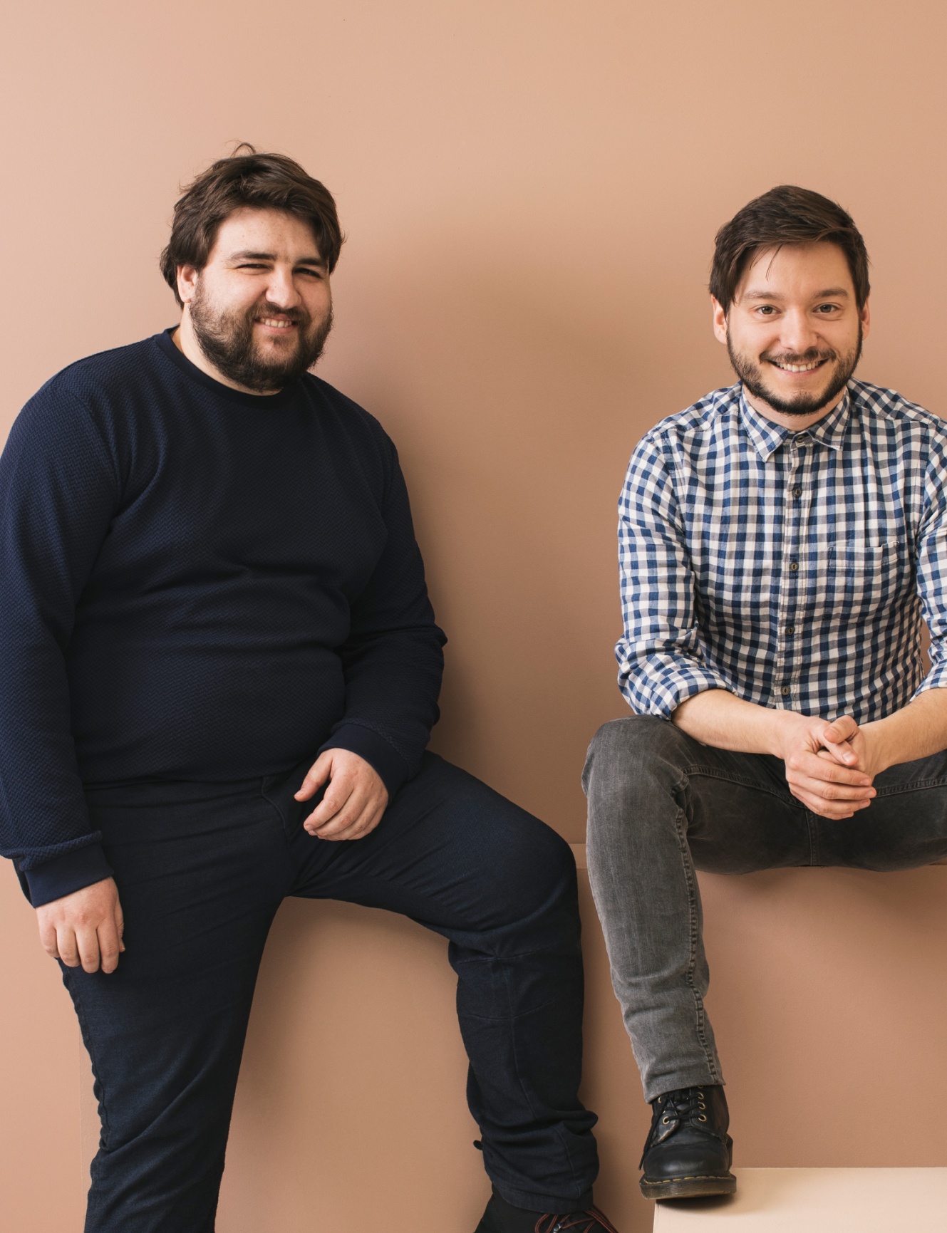 Two men sitting together smiling in their office.