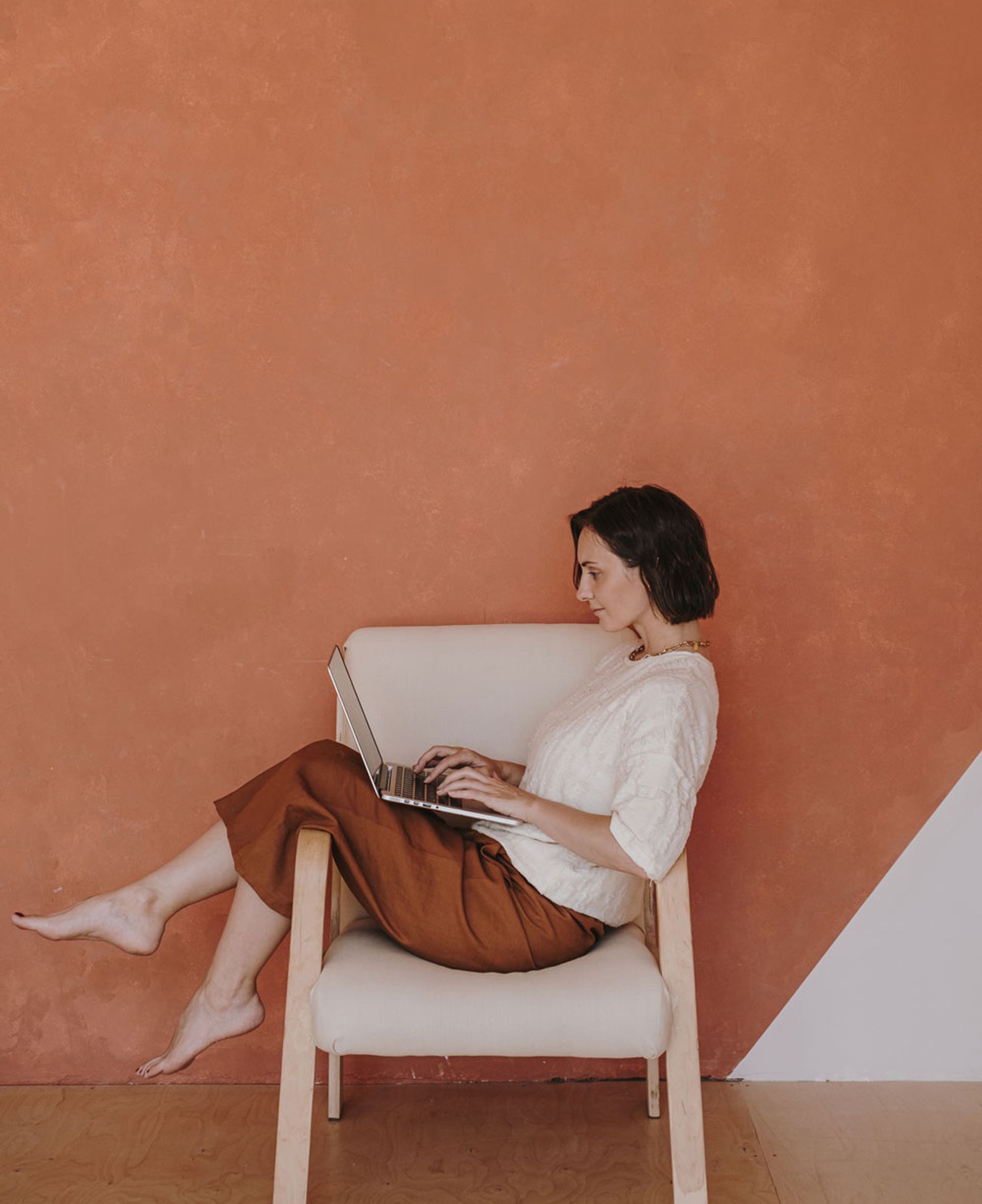 Woman with laptop on chair. 