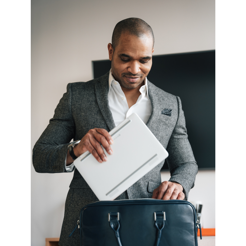 Business man putting a laptop into his breifcase