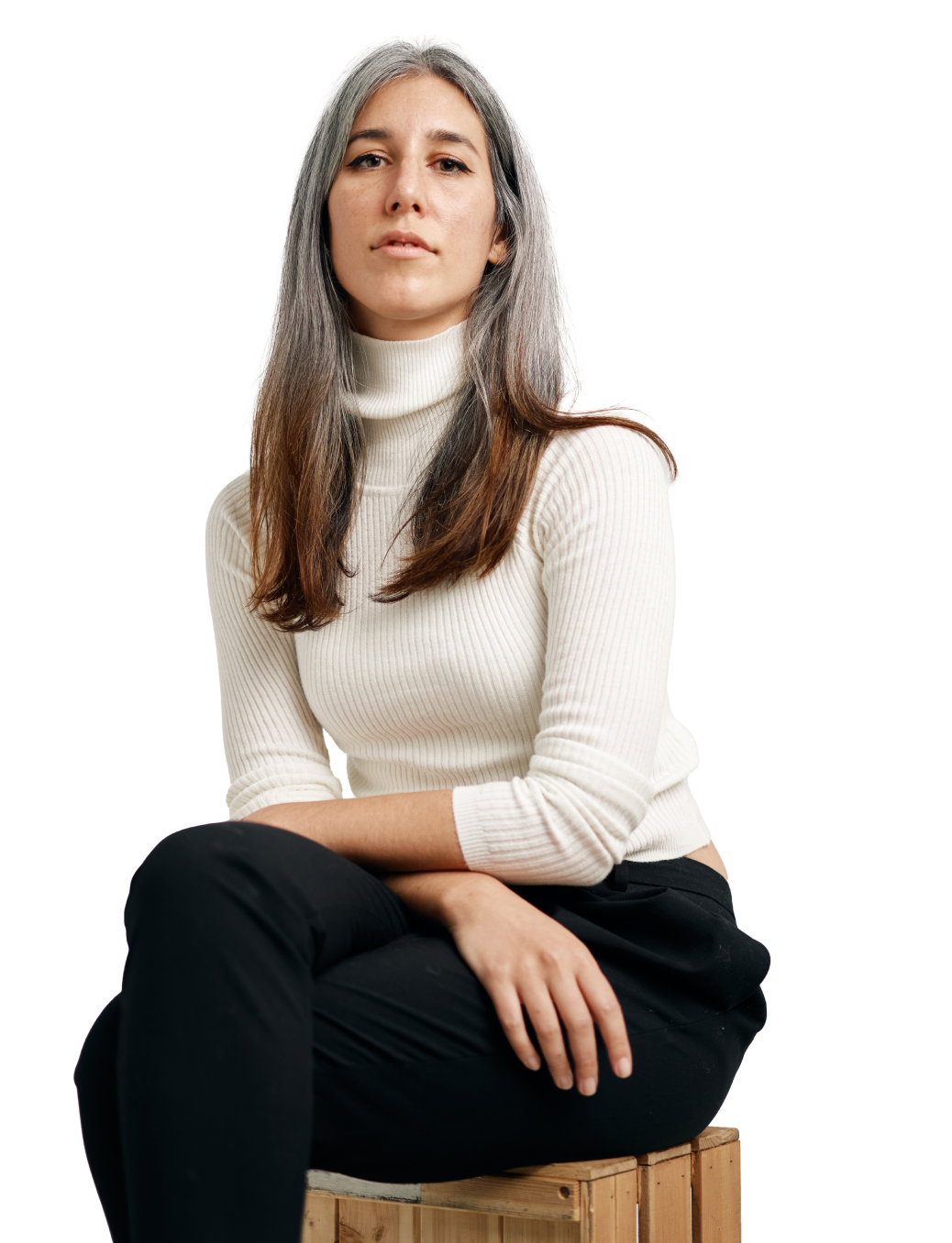 female startup employee in a white jumper sitting with her arms crossed on her lap