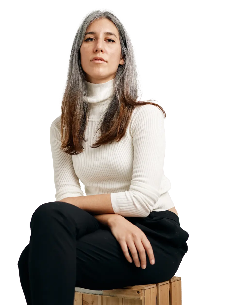 female startup employee in a white jumper sitting with her arms crossed on her lap