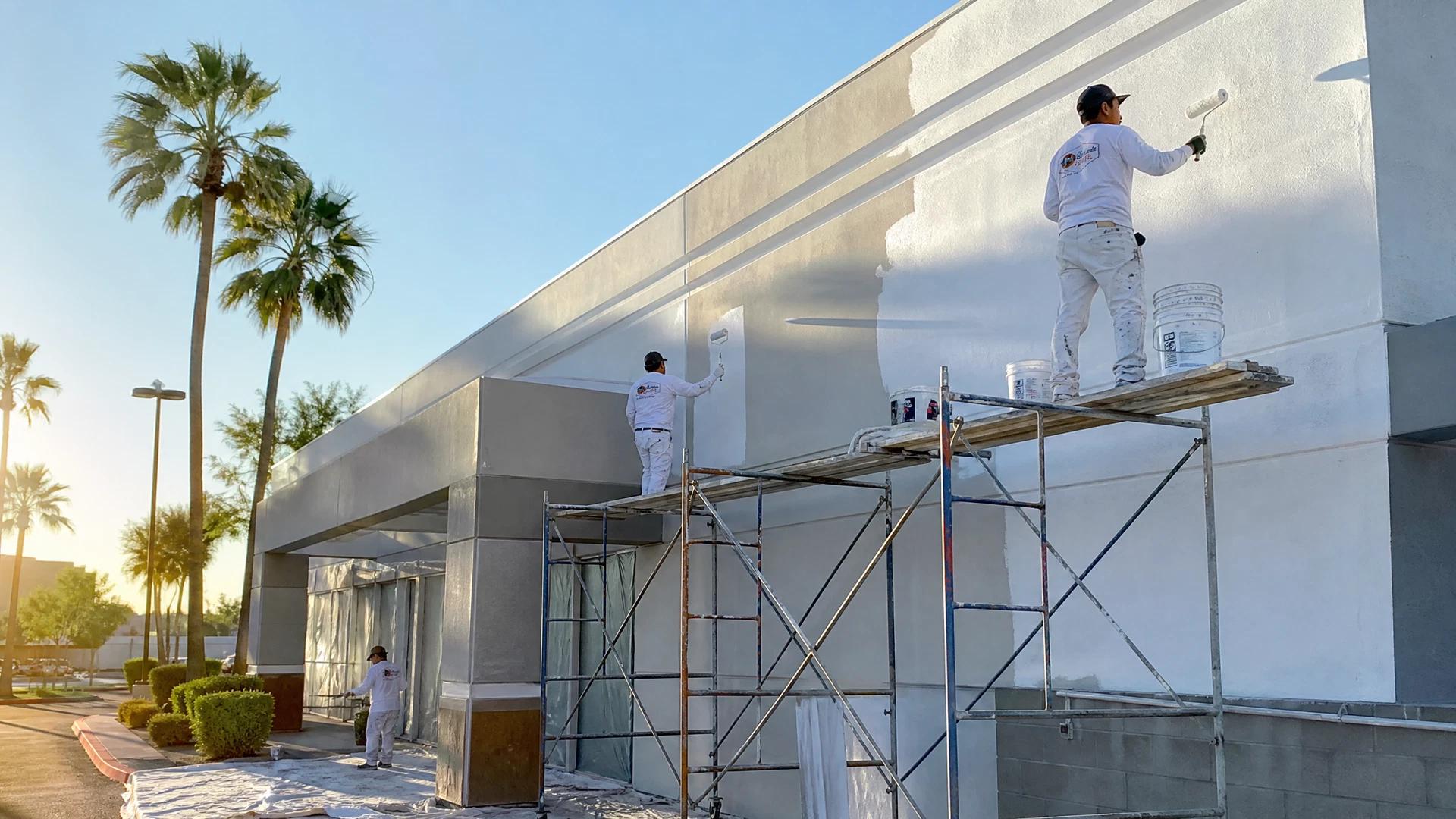Painter applying fresh paint to an exterior wall
