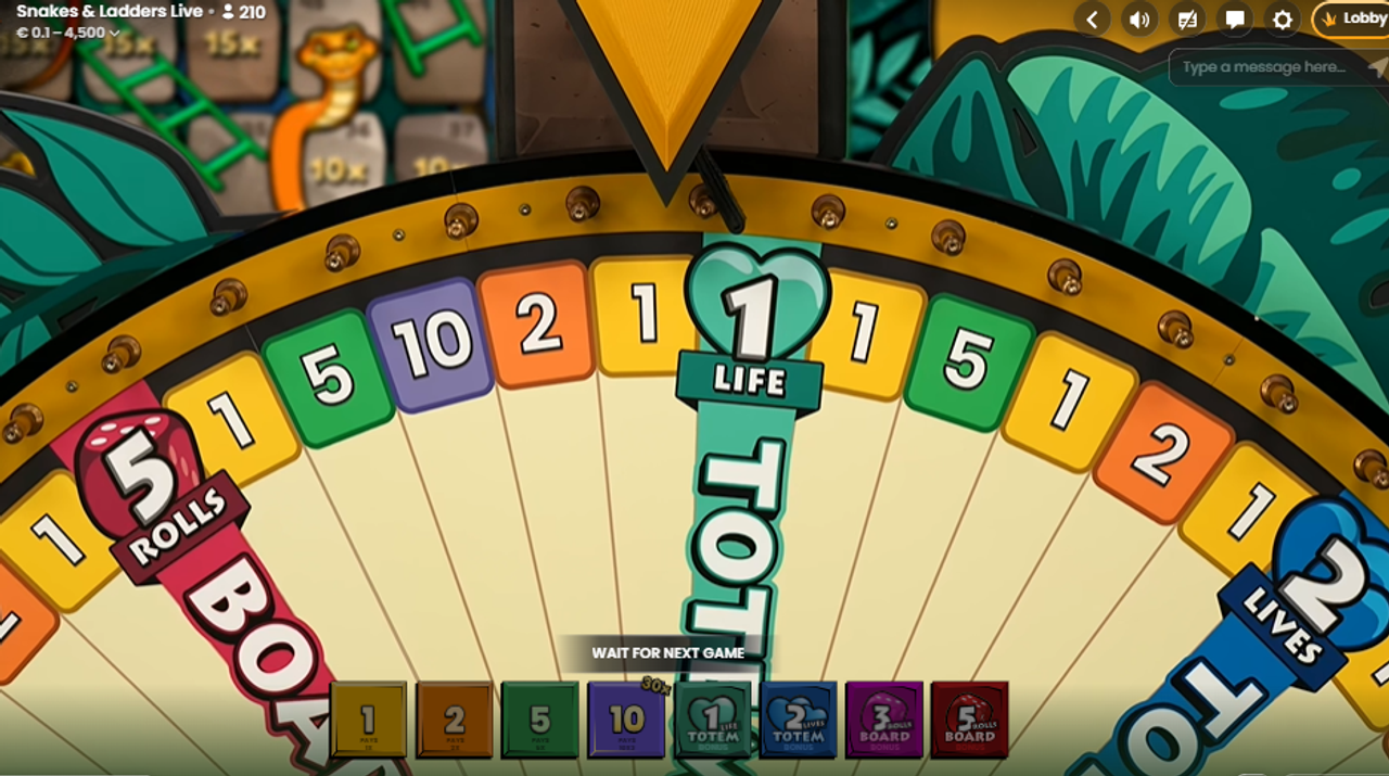 Snake&Ladders Liven pelipyörä, jossa on numerot 1, 2, 5, ja 10 sekä neljä erilaista bonuspeliä, on pysähtynyt numeroon 1.