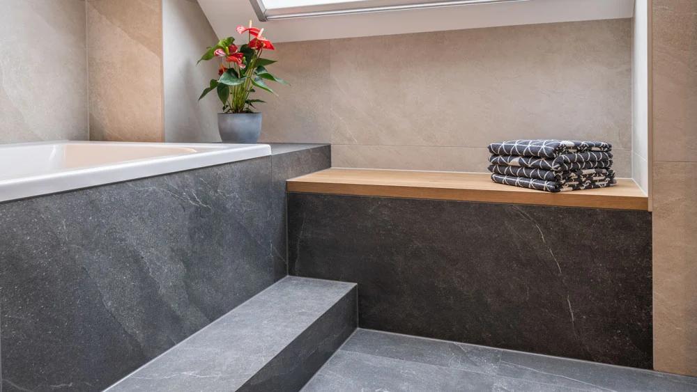 Modernes Badezimmer mit Badewanne, Holzregal und Pflanzen.
