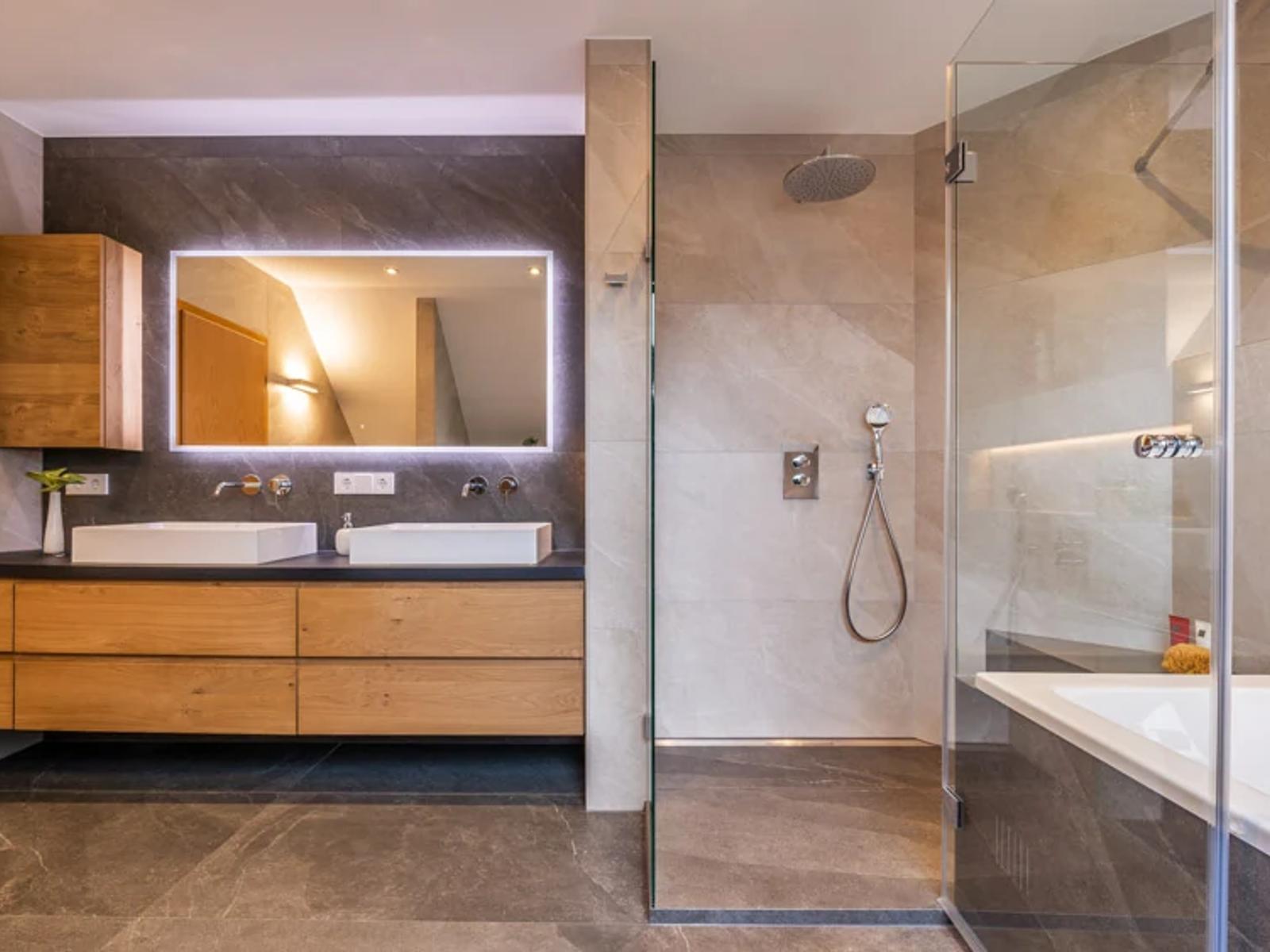 Modernes Badezimmer mit Holzschränken und zwei Waschbecken.