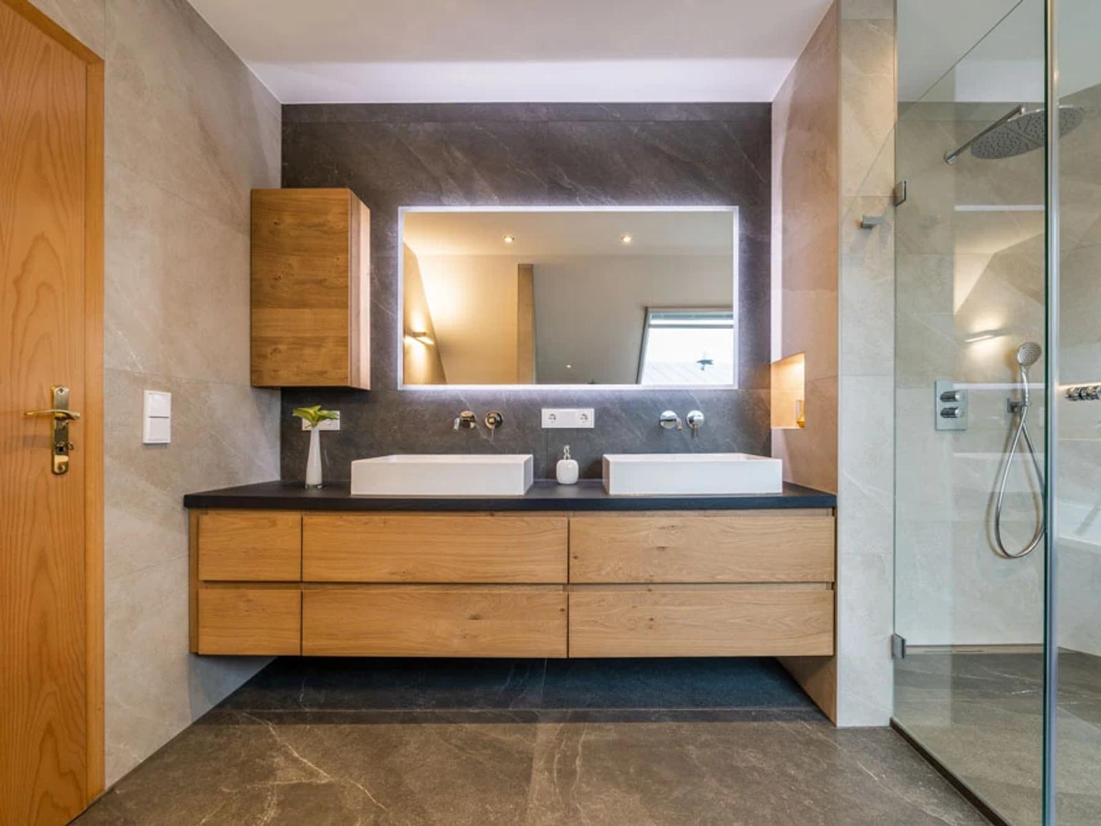 Modernes Badezimmer mit Holzschränken und Doppelwaschbecken.