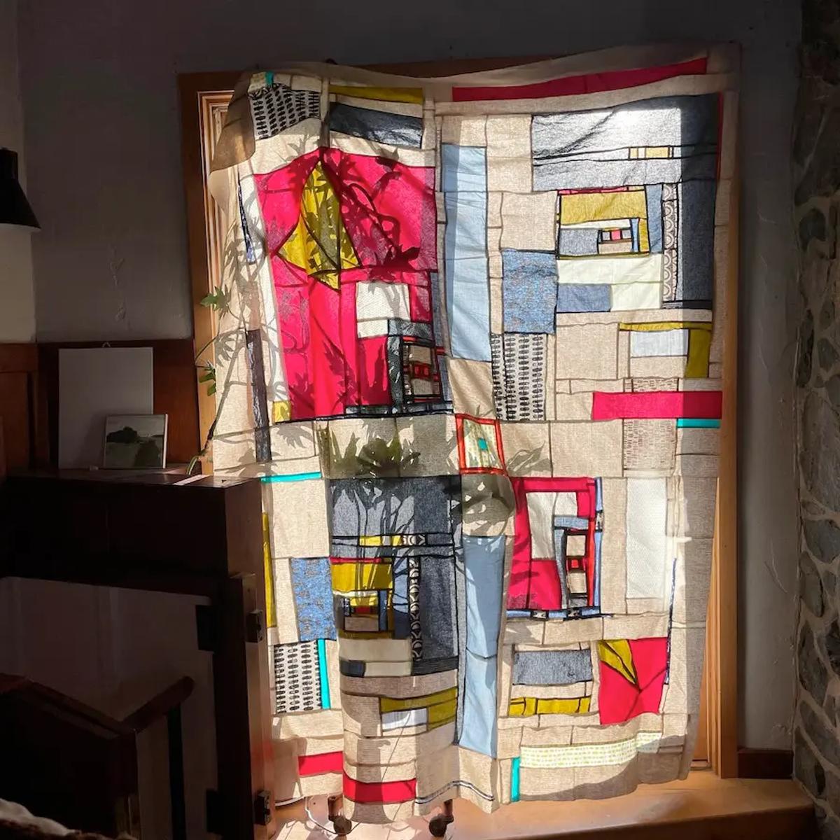 Modernist quilt hanging over a window