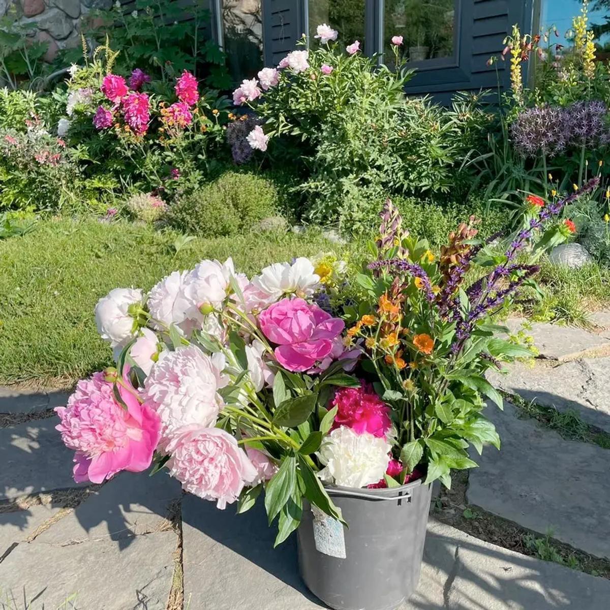 A large bucket overflowing with peonies