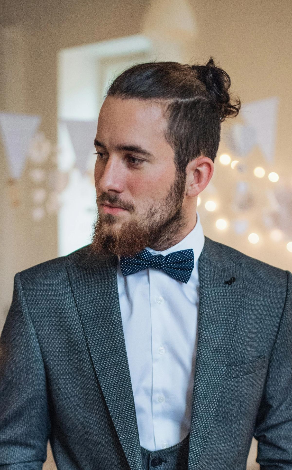 Man in textured tuxedo with party in the background
