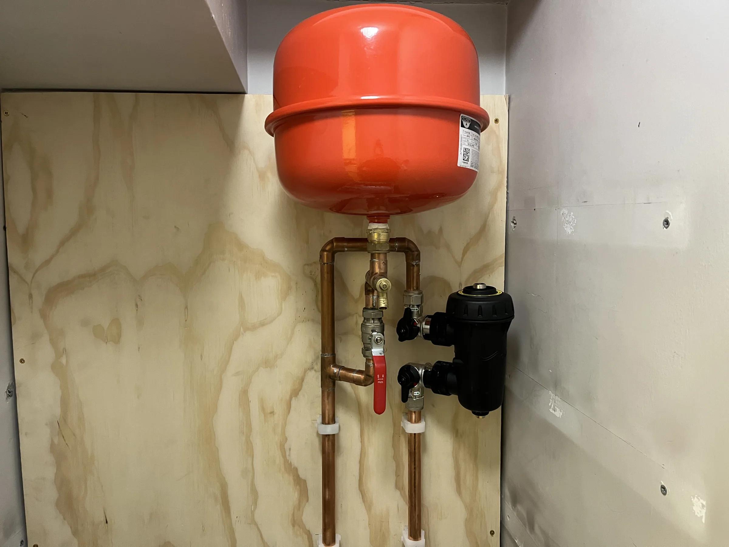 An expansion vessel and system filter fitted onto sealed-system pipework
