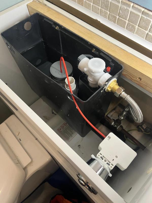 Central heating pipework and valves exposed under lifted floorboards