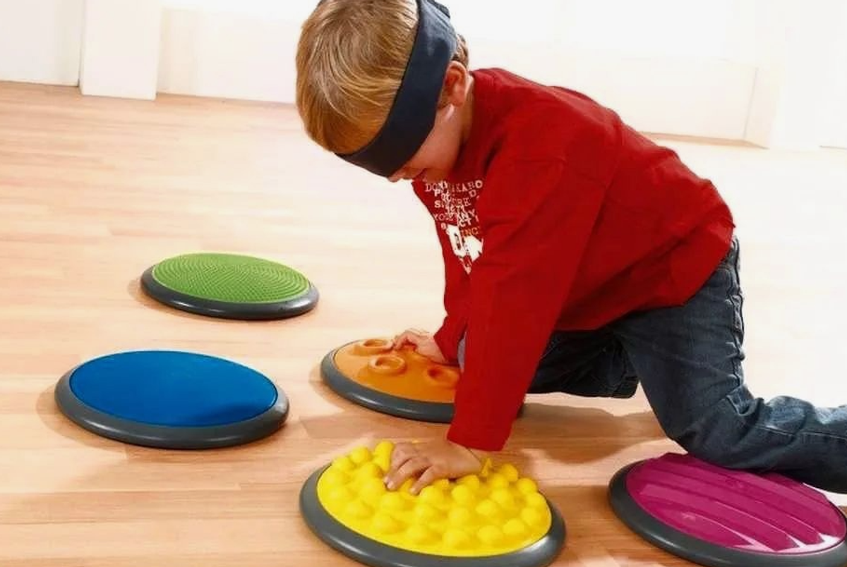 Play-Based Therapy for Sensory Integration - A child exploring different textures with kinetic sand, enhancing tactile sensitivity and sensory processing.