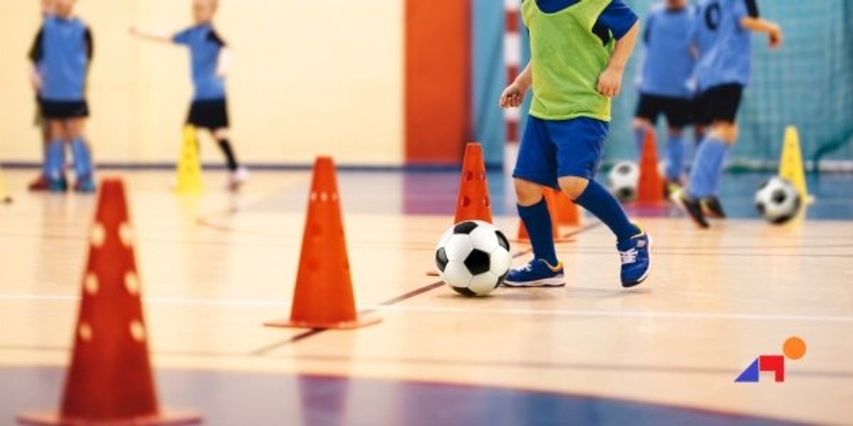 a boy kicking a football ball for pediatric physical therapy