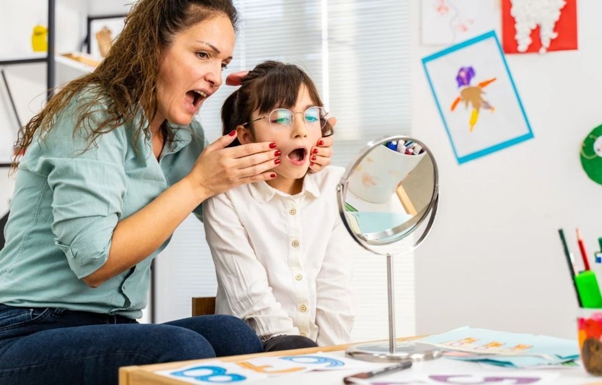 a woman looking at a child's face during speech therapy in vancouver
