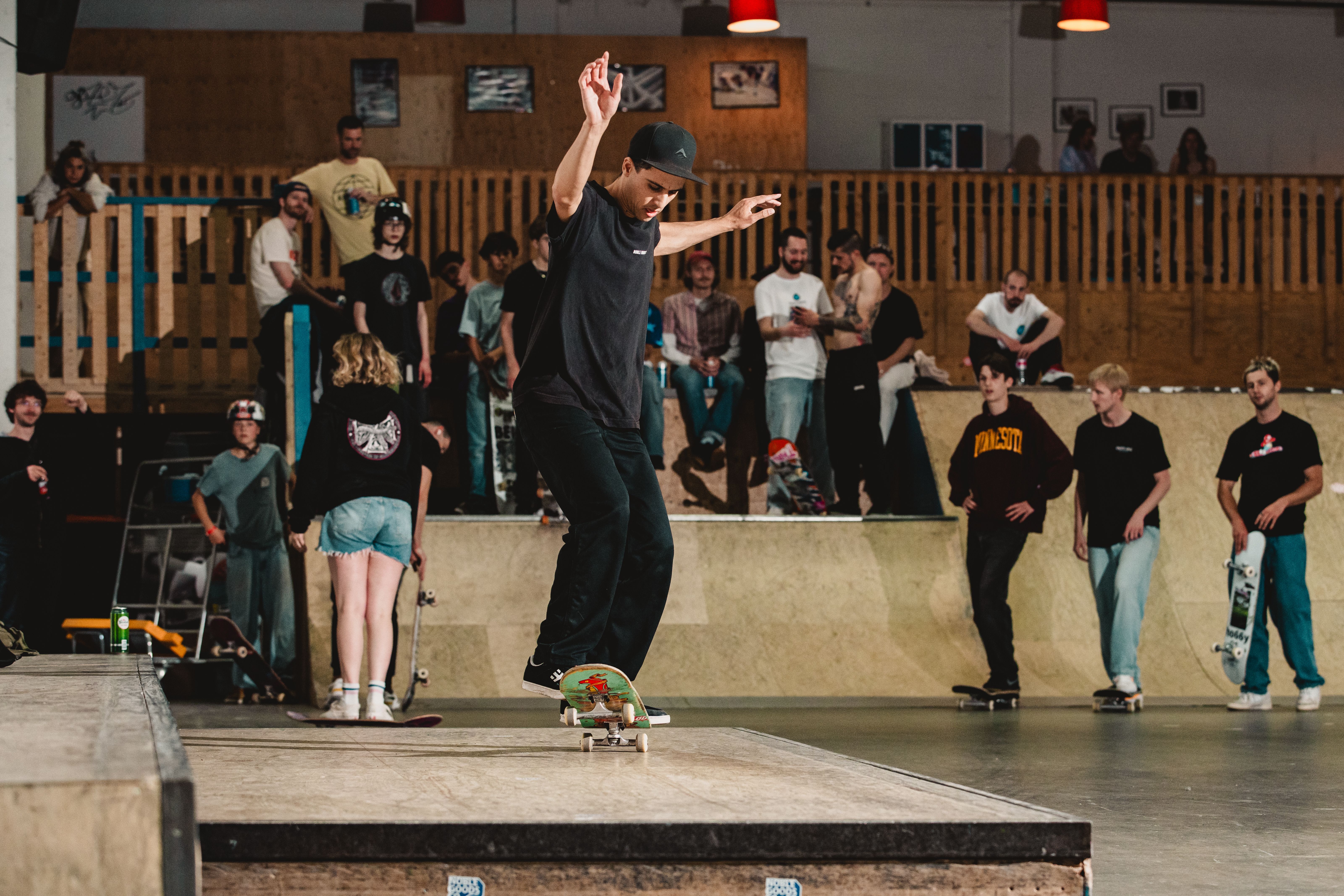 Een skater op een obstakel, met publiek er omheen.