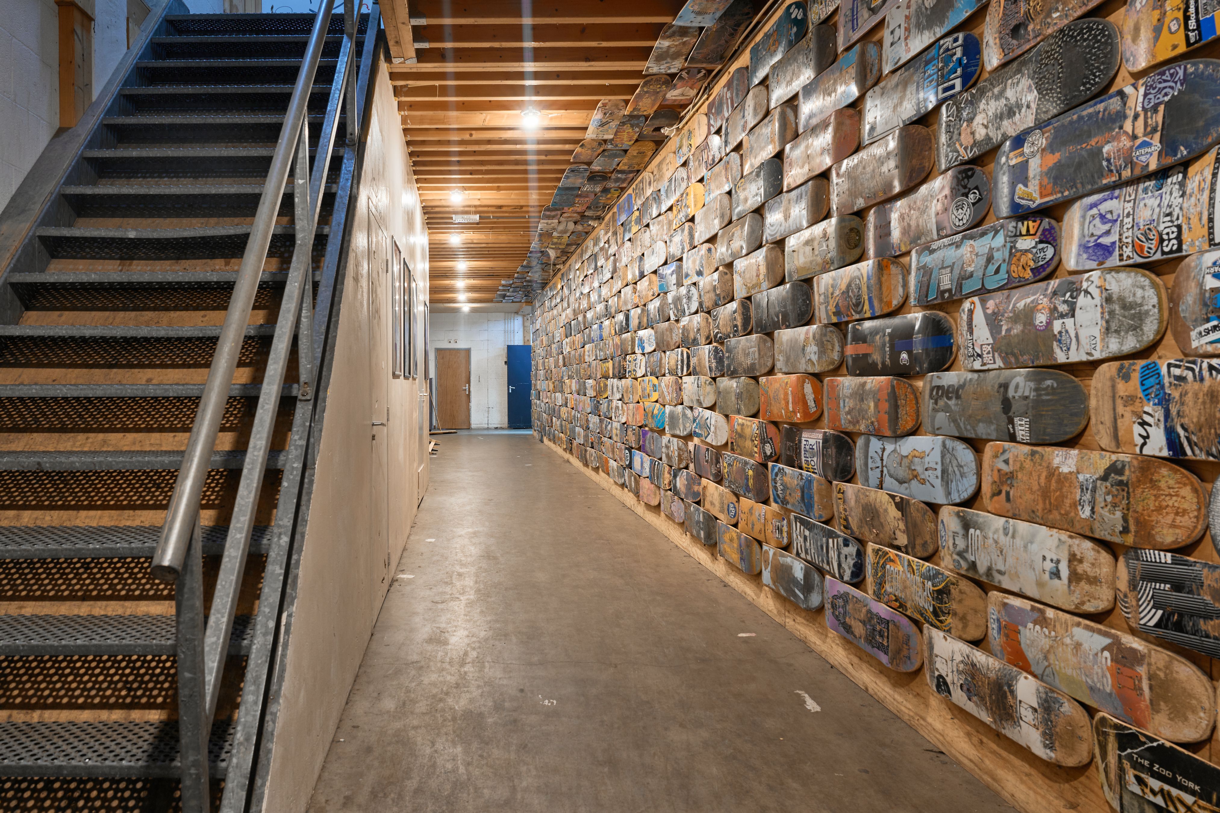 [PLACEHOLDER] De gang langs de wand die helemaal is volgezet met oude boards