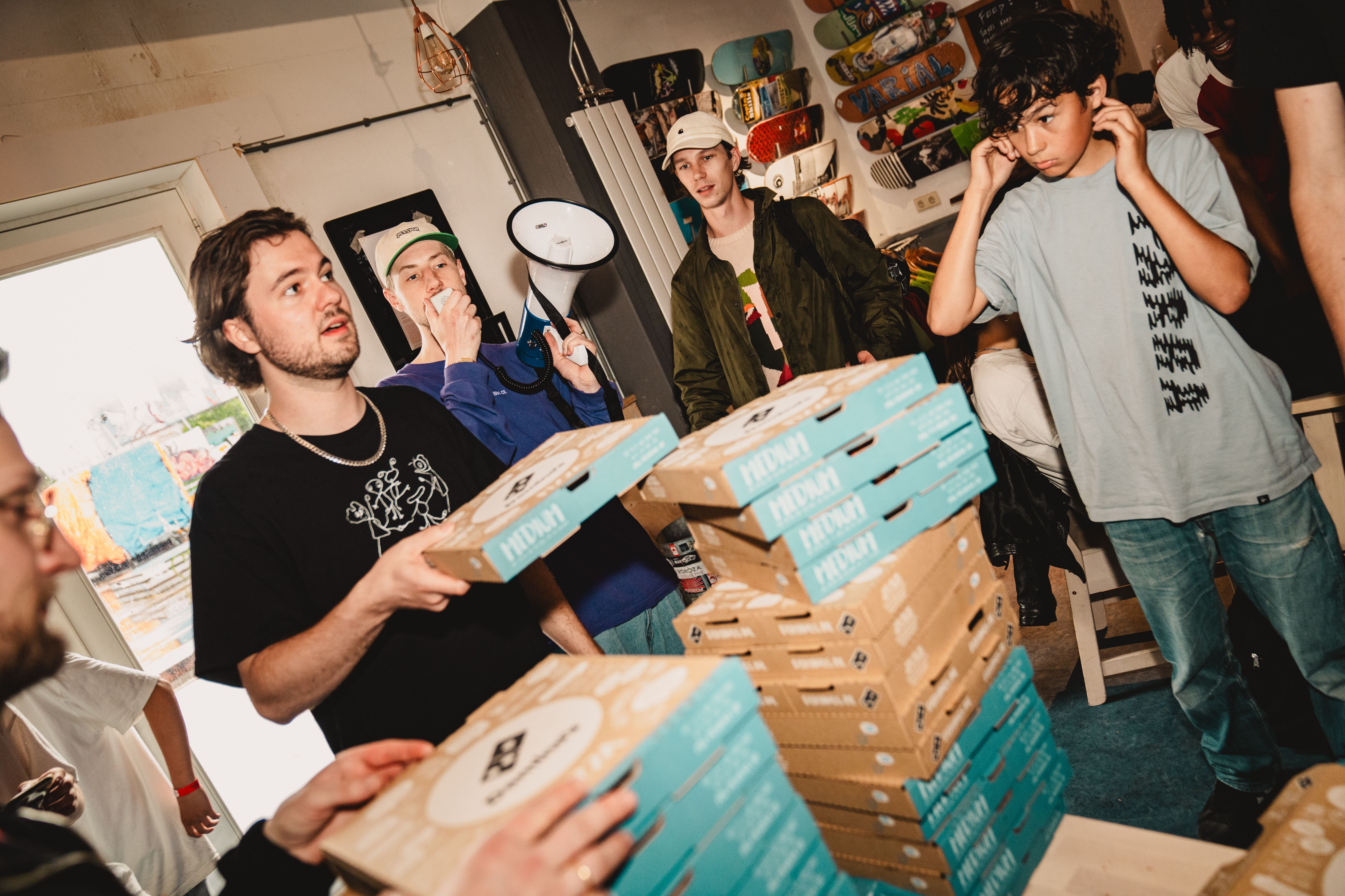 [PLACEHOLDER] Stapels pizzadozen gaan rond tussen de bezoekers