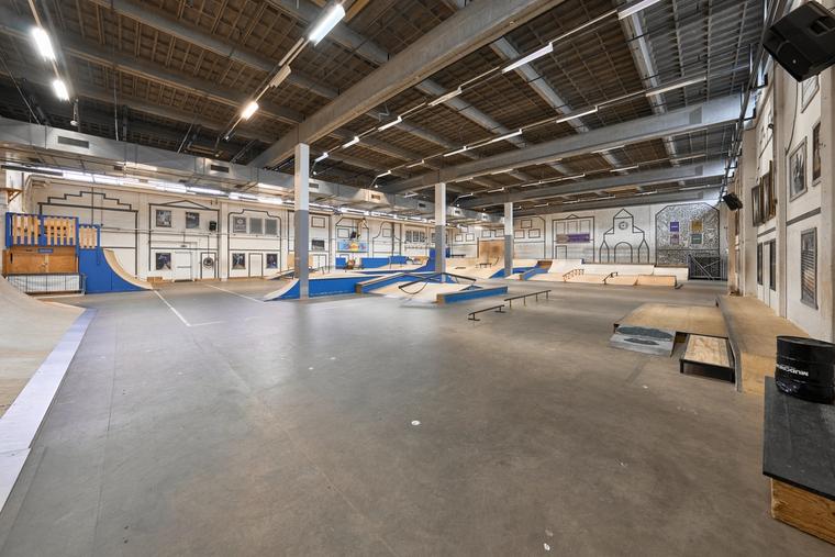 De open betonvloer van het park, leeg, met de obstakels langs de randen.