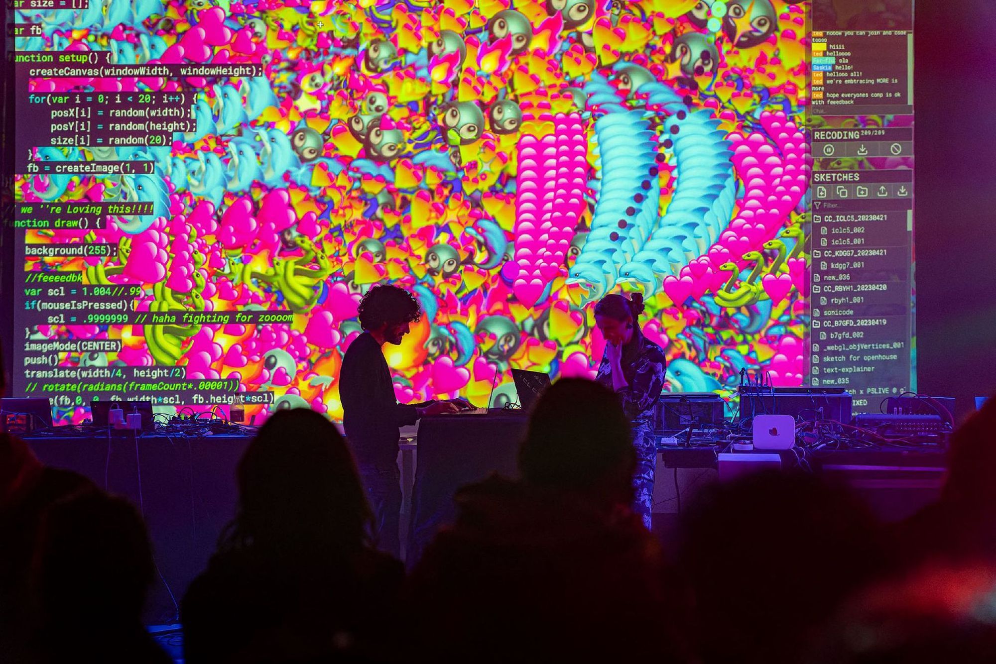Two people are playing instruments in front of a large projection screen