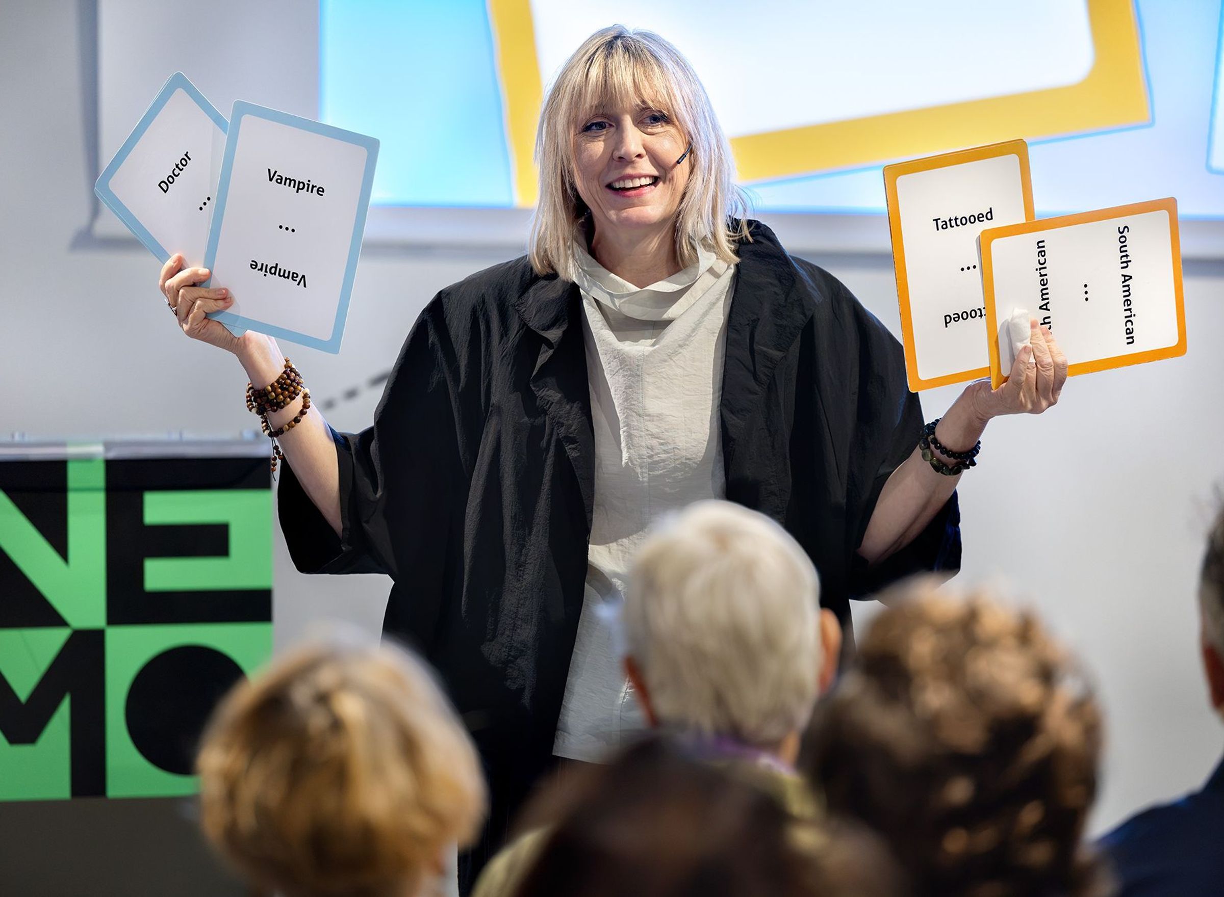 a woman holding up four cards with text