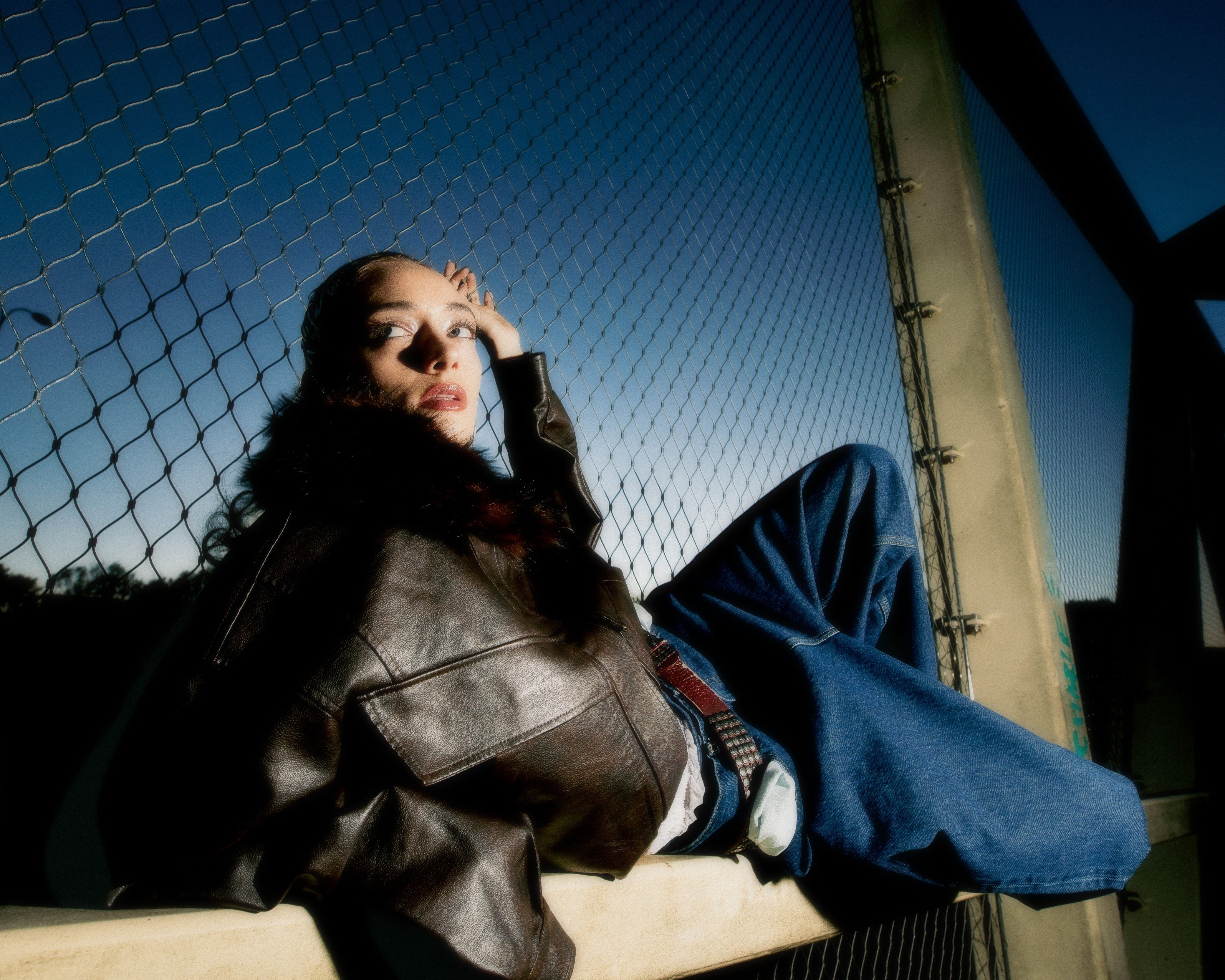 a girl posing in front of a fence