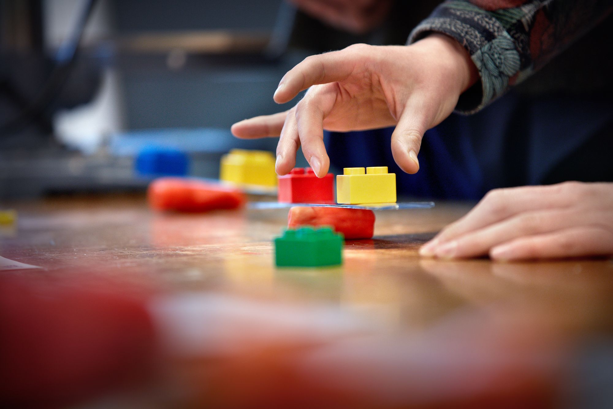 Een balancerend stukje karton waar aan weerszijden twee lego-blokjes gebalanceerd worden.