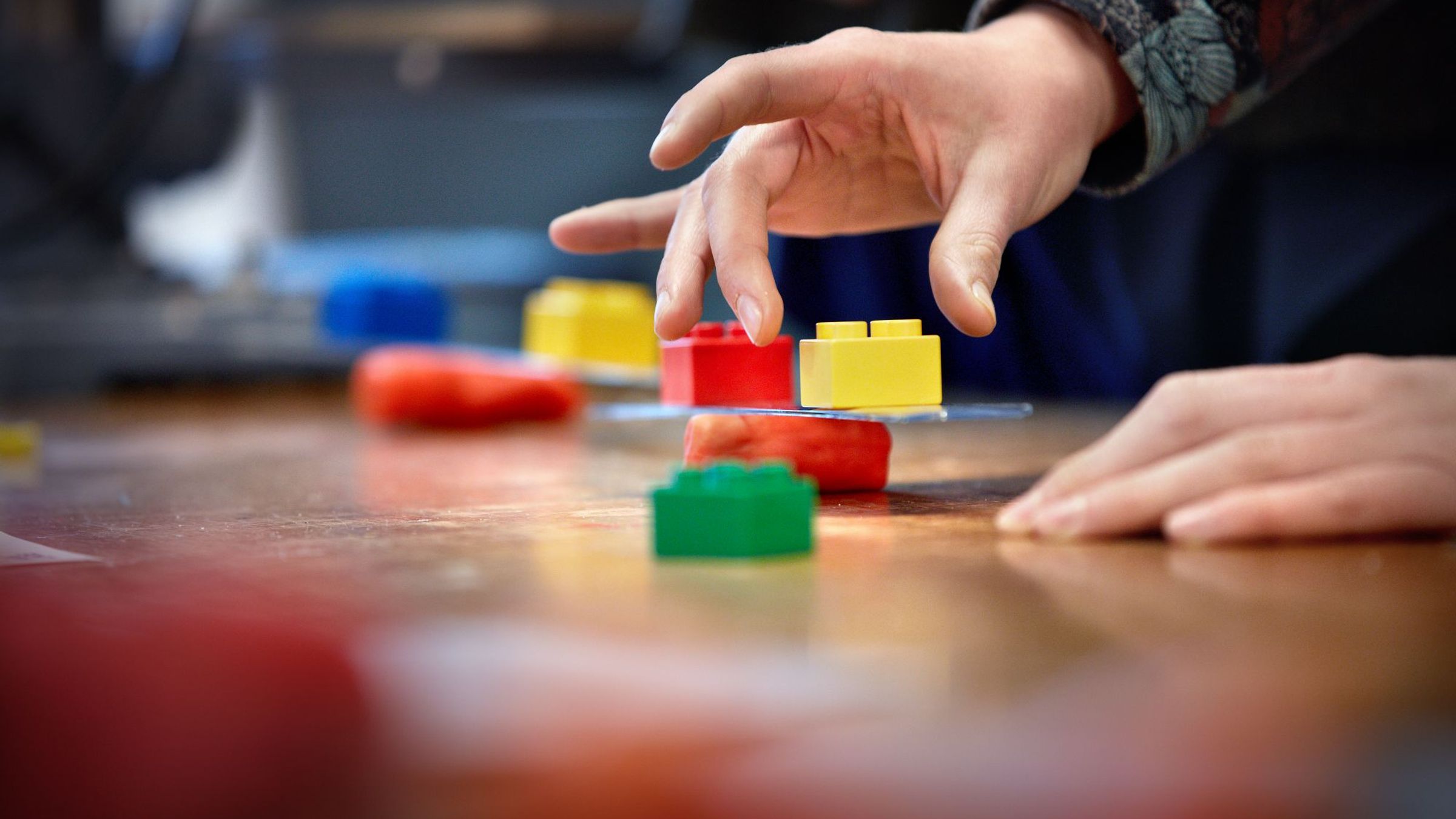 Een balancerend stukje karton waar aan weerszijden twee lego-blokjes gebalanceerd worden.