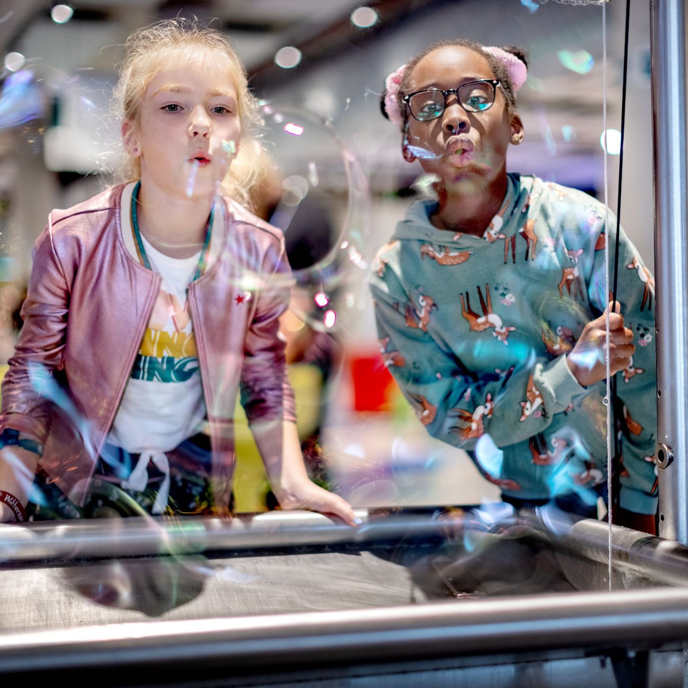 two girls blowing soapy bubbles