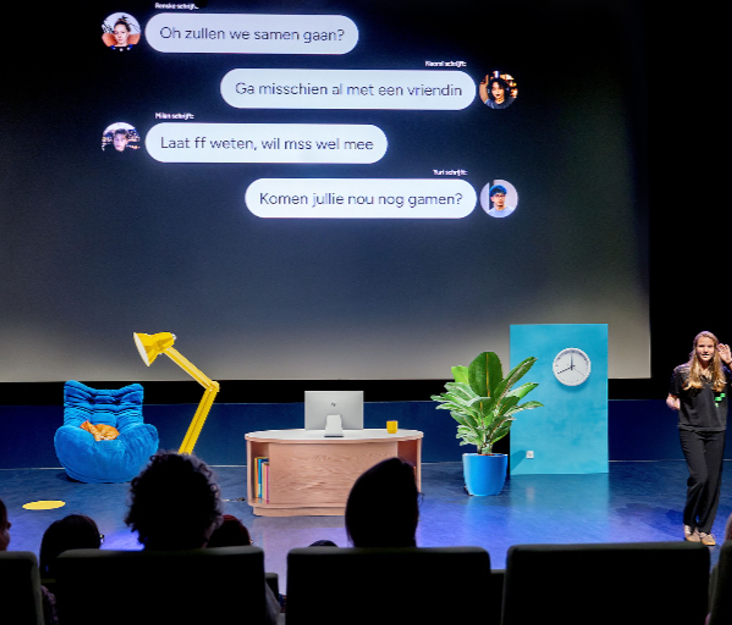 een vrouw staat voor een groot beeldscherm met daarop een een chatgesprek