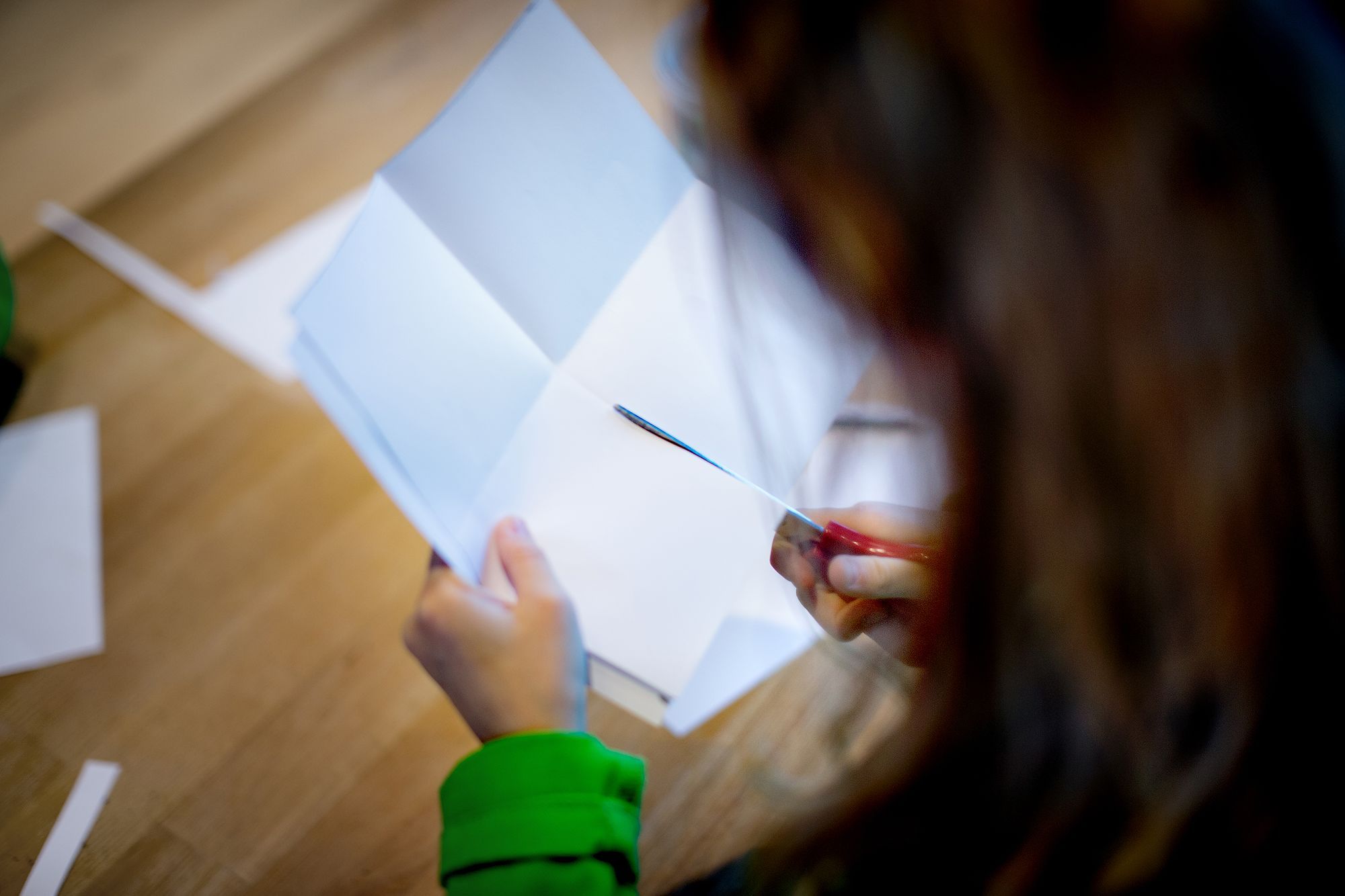 Een kind knipt met een schaar in een papier.