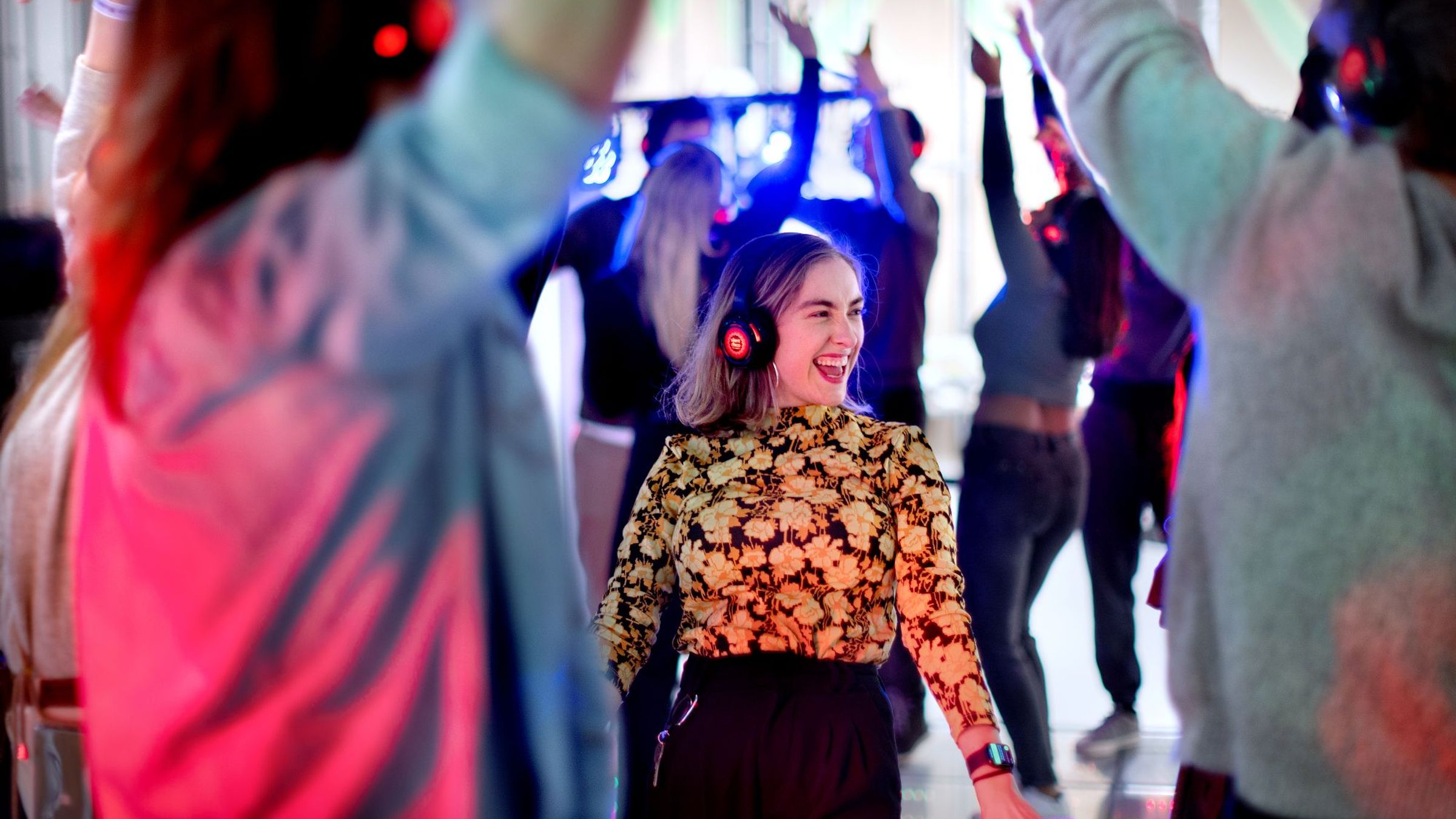 Een vrouw staat met een koptelefoon op te dansen.