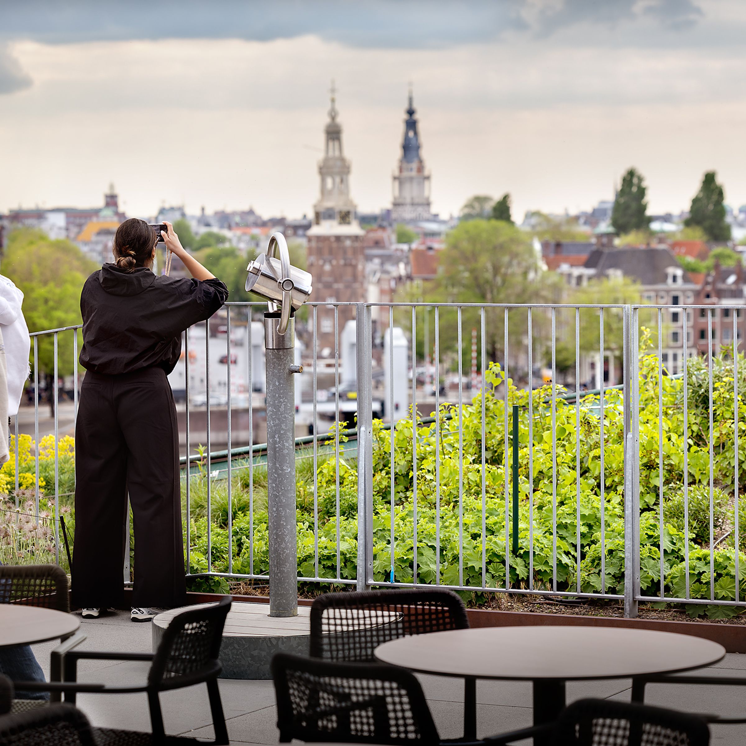Two people are enjoying the view from the rooftop terrace