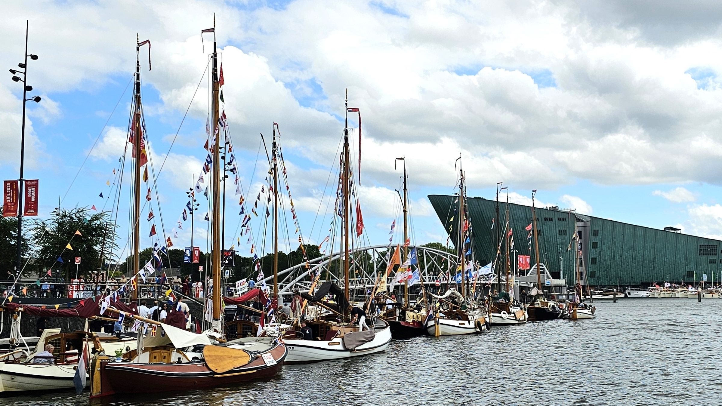 boten met kleurrijke vlaggenlijnen in de haven met NEMO op de achtergrond