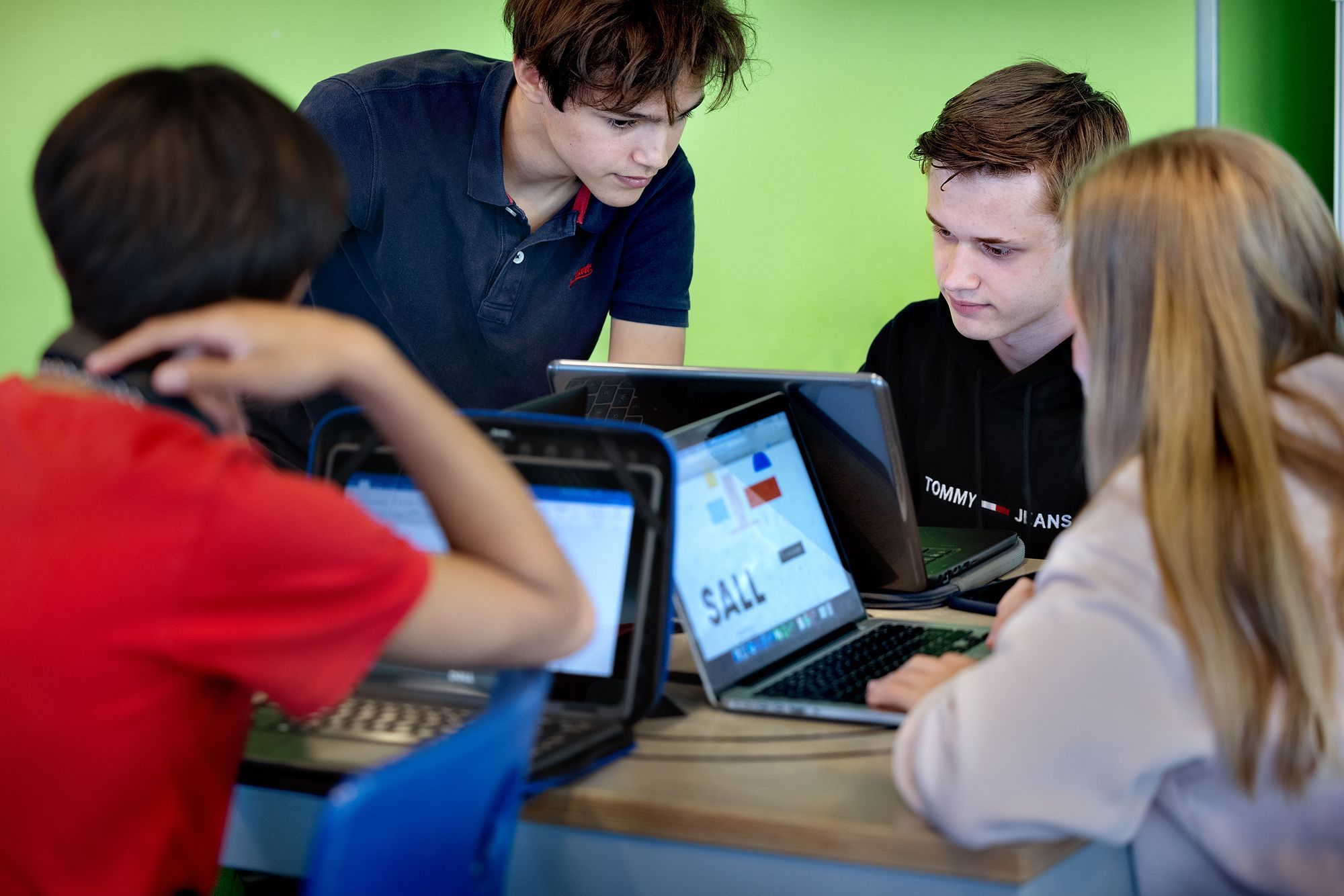 Twee jongens kijken samen naar een laptopscherm.