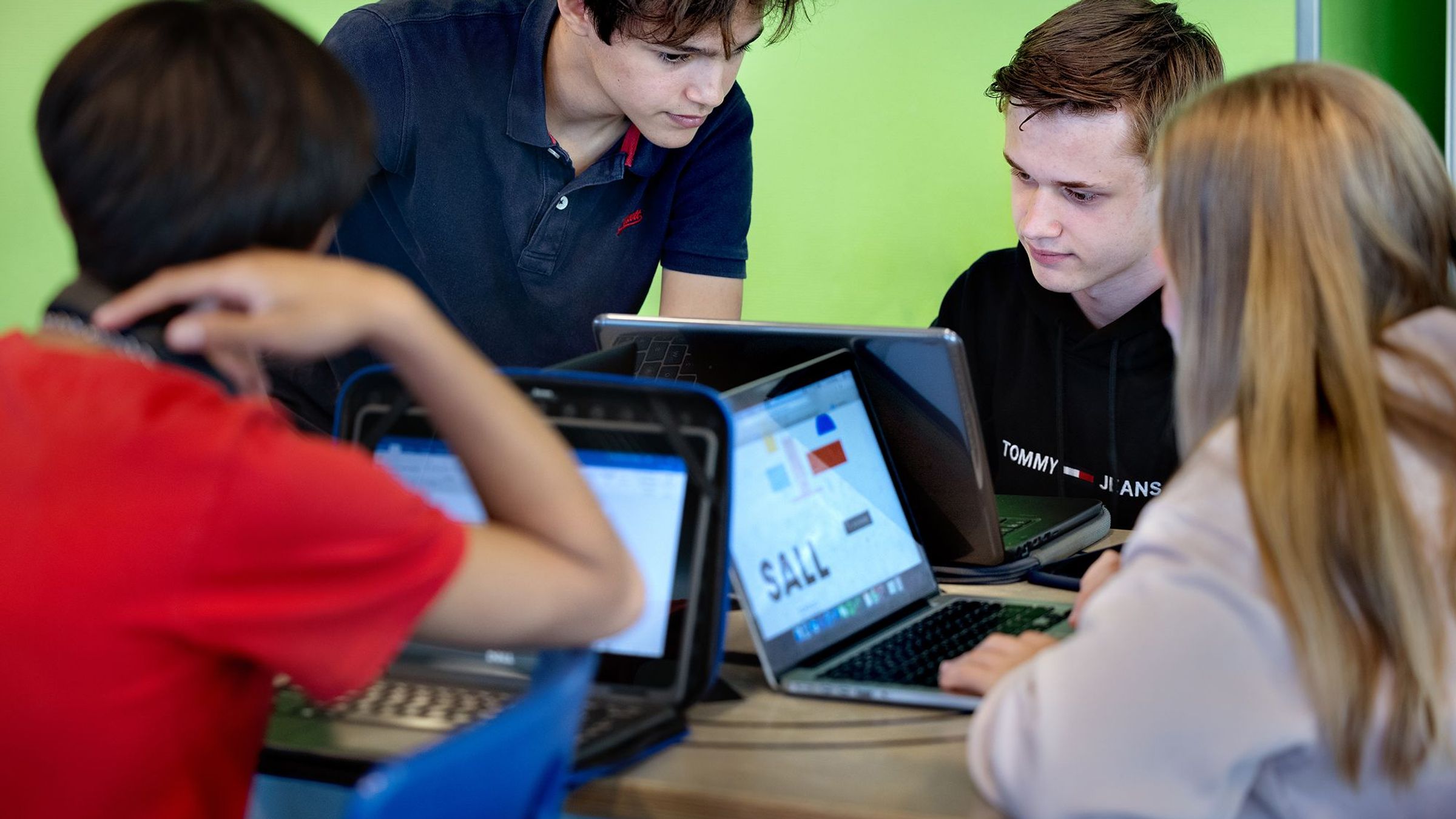 Twee jongens kijken samen naar een laptopscherm.