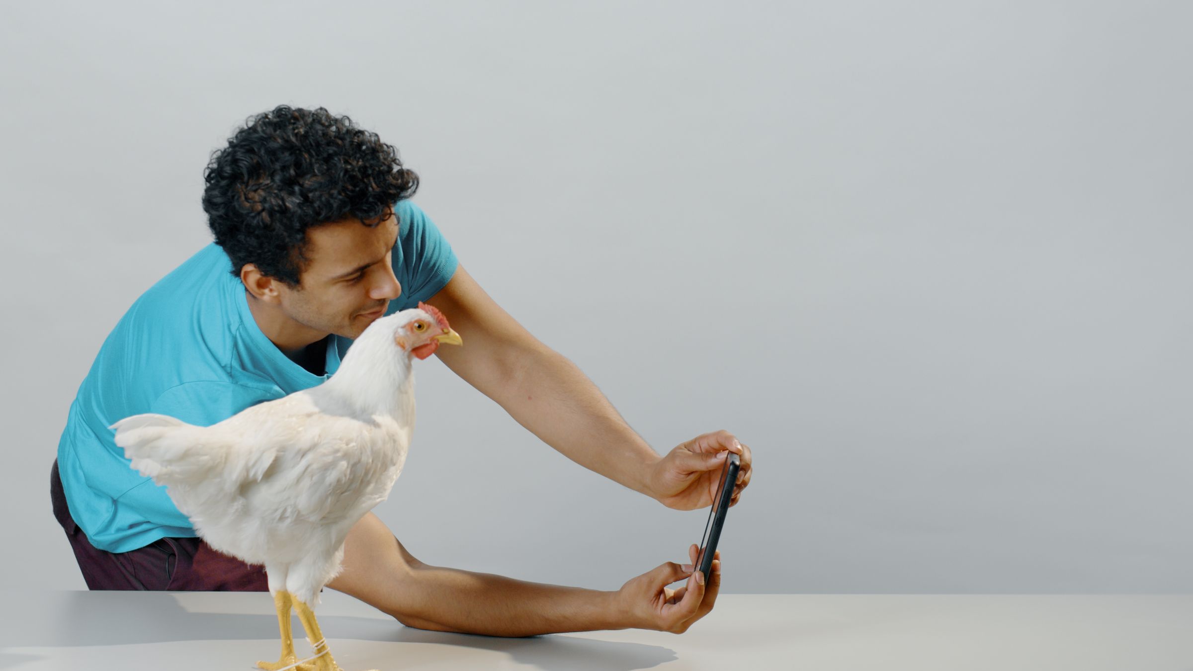 A man takes a selfie with a chicken