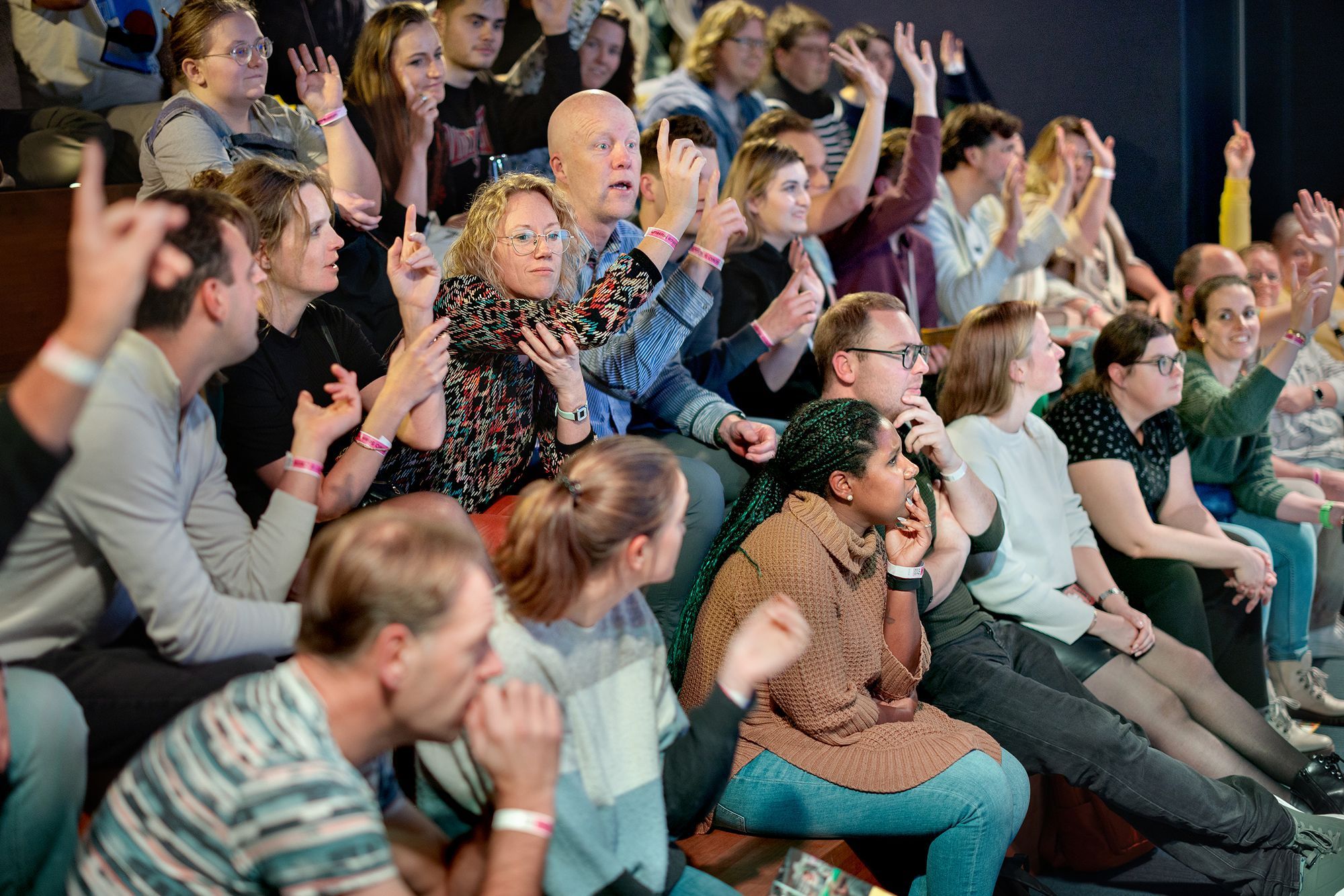 Luisterend publiek met vingers omhoog