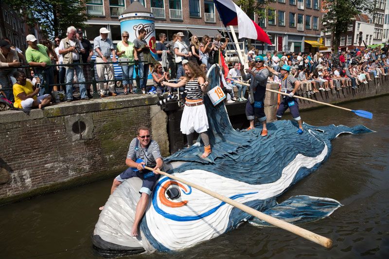drie mensen varen op een zelfgemaakte boot die op een walvis lijkt