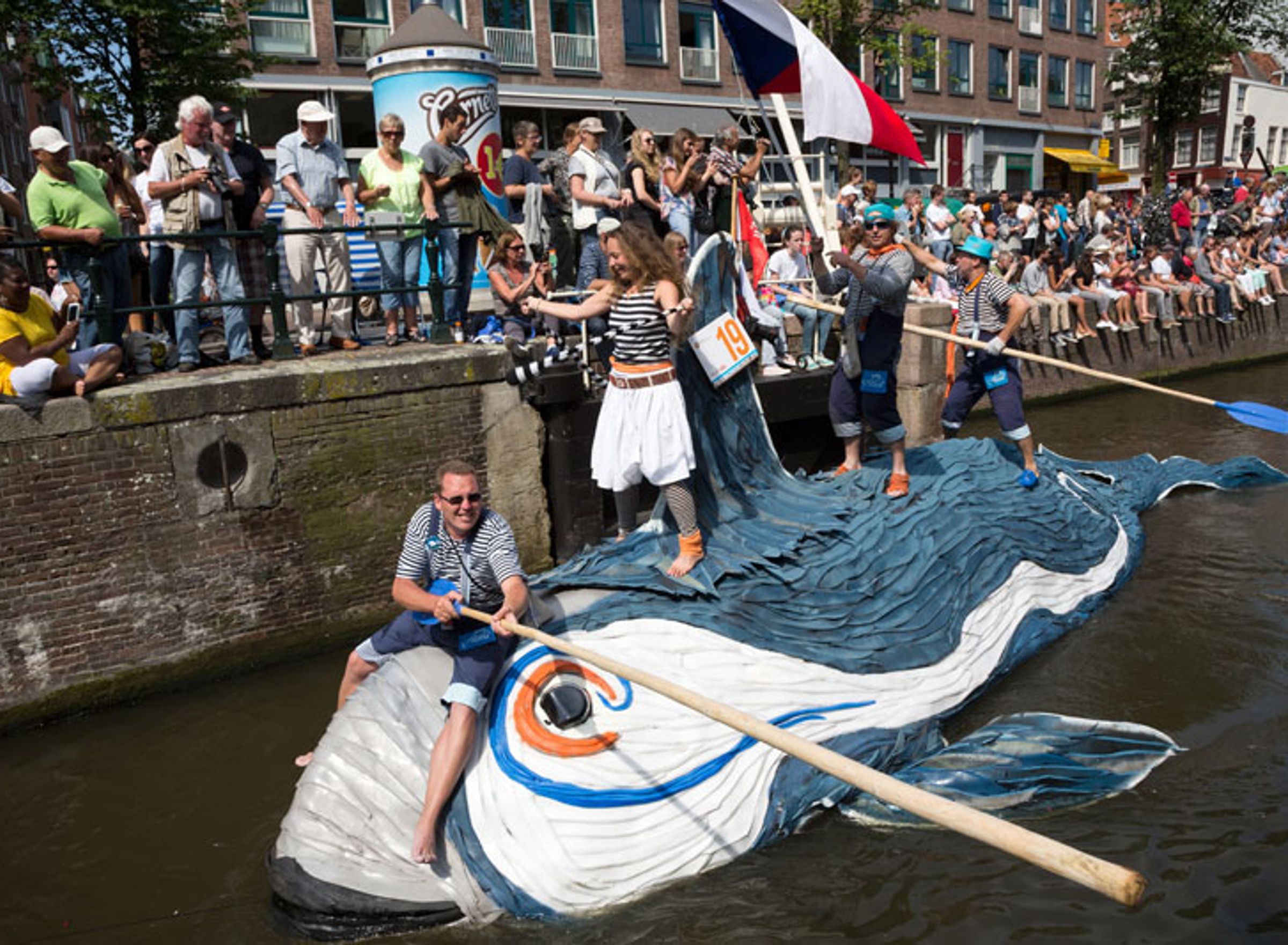drie mensen varen op een zelfgemaakte boot die op een walvis lijkt