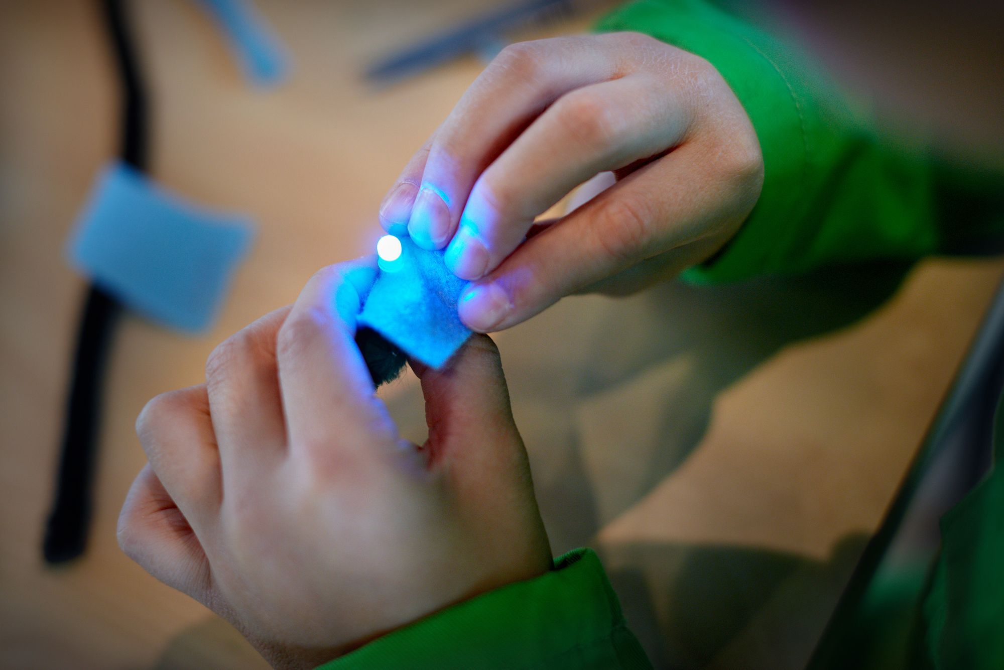 Twee handen spelen met een klein LED-lampje