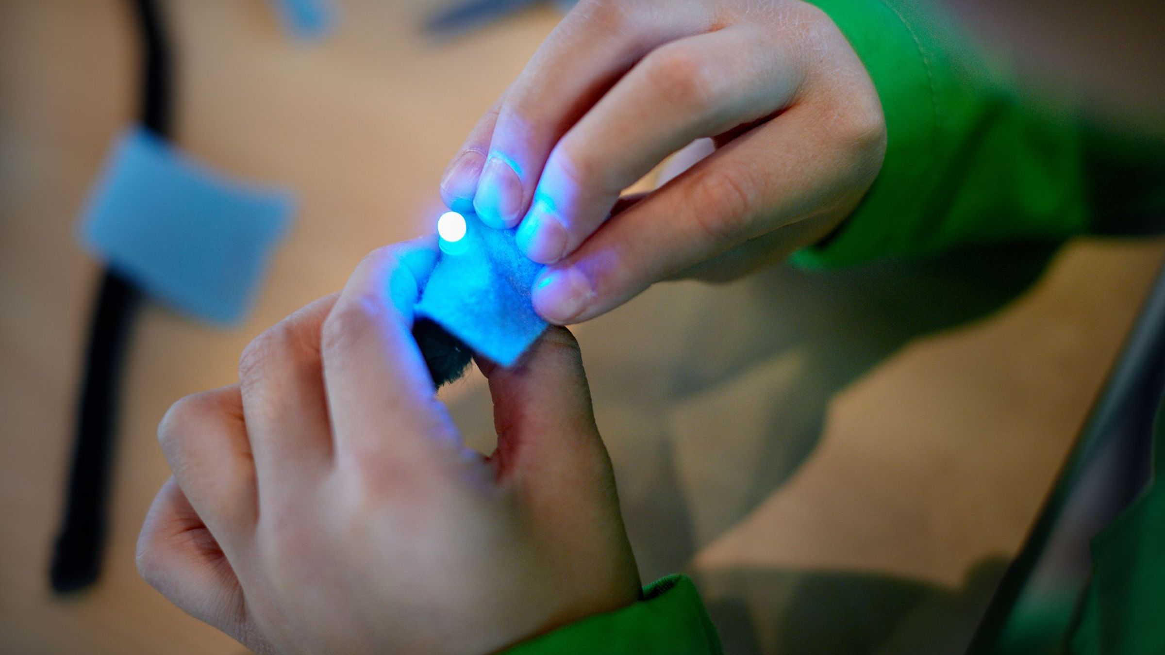 Twee handen spelen met een klein LED-lampje