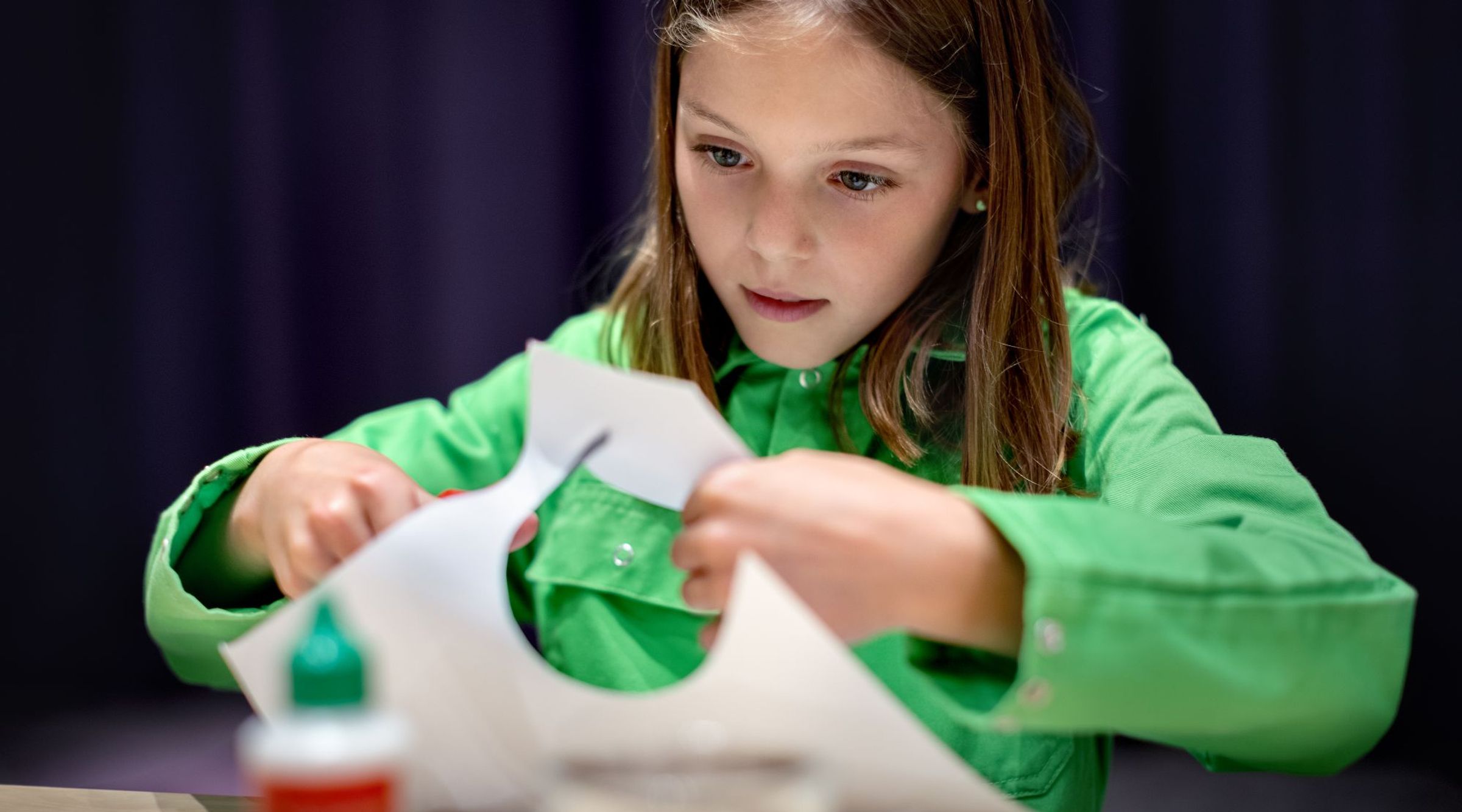 Een meisje knipt een cirkel uit papier
