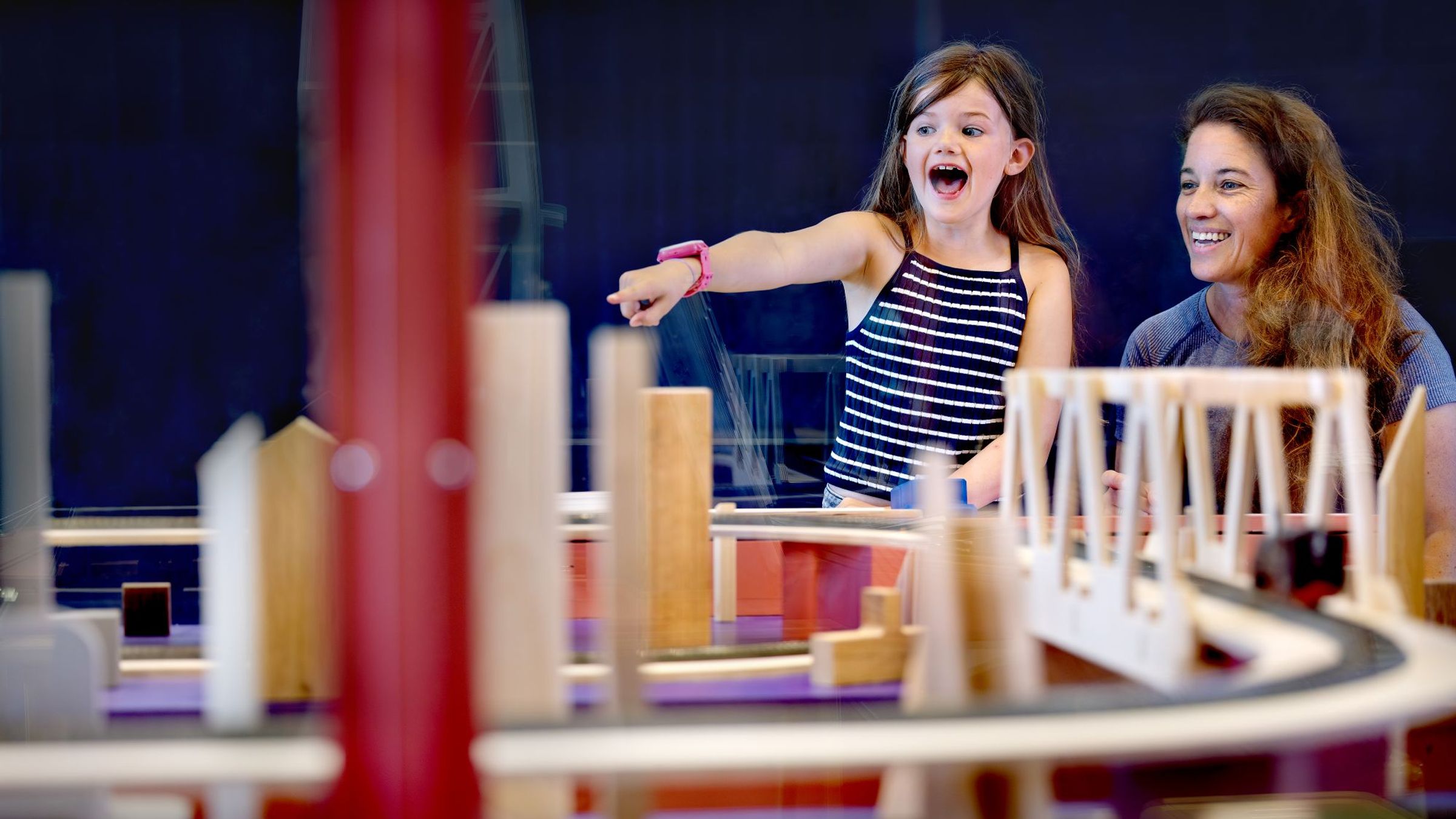 girl points enthusiastically, woman smiles