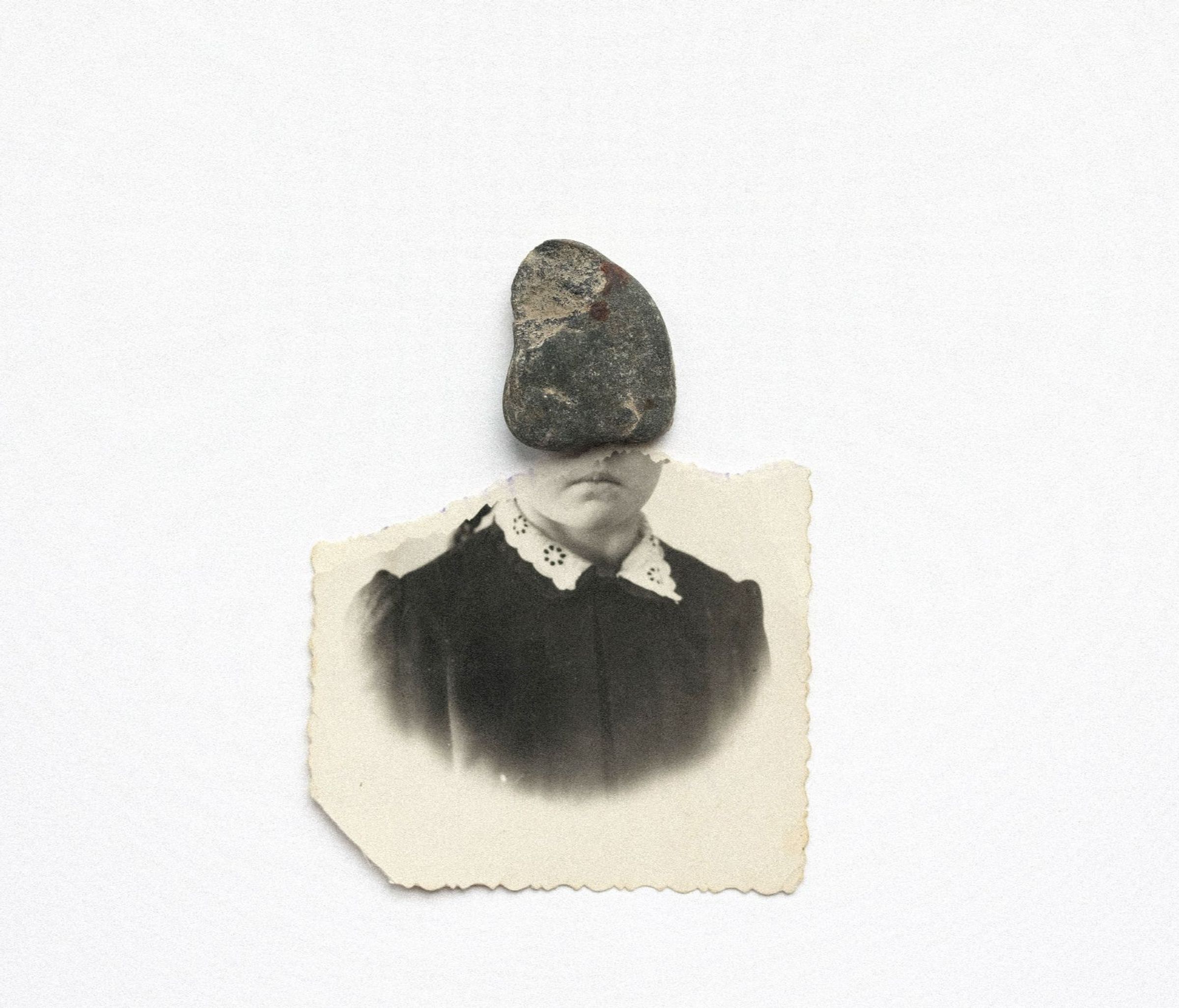 a torn photo with a stone