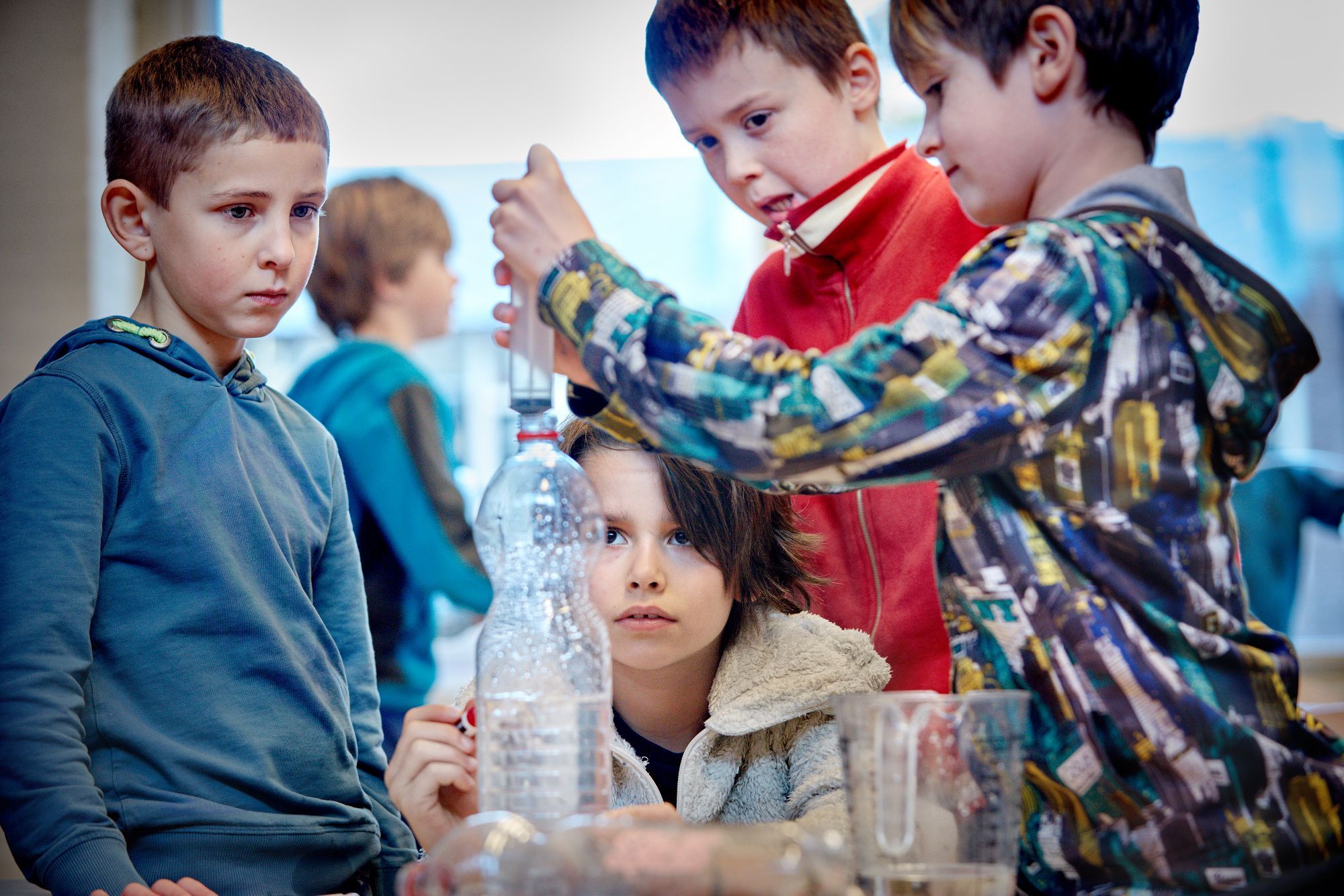 Vier jongens doen water in een fles.