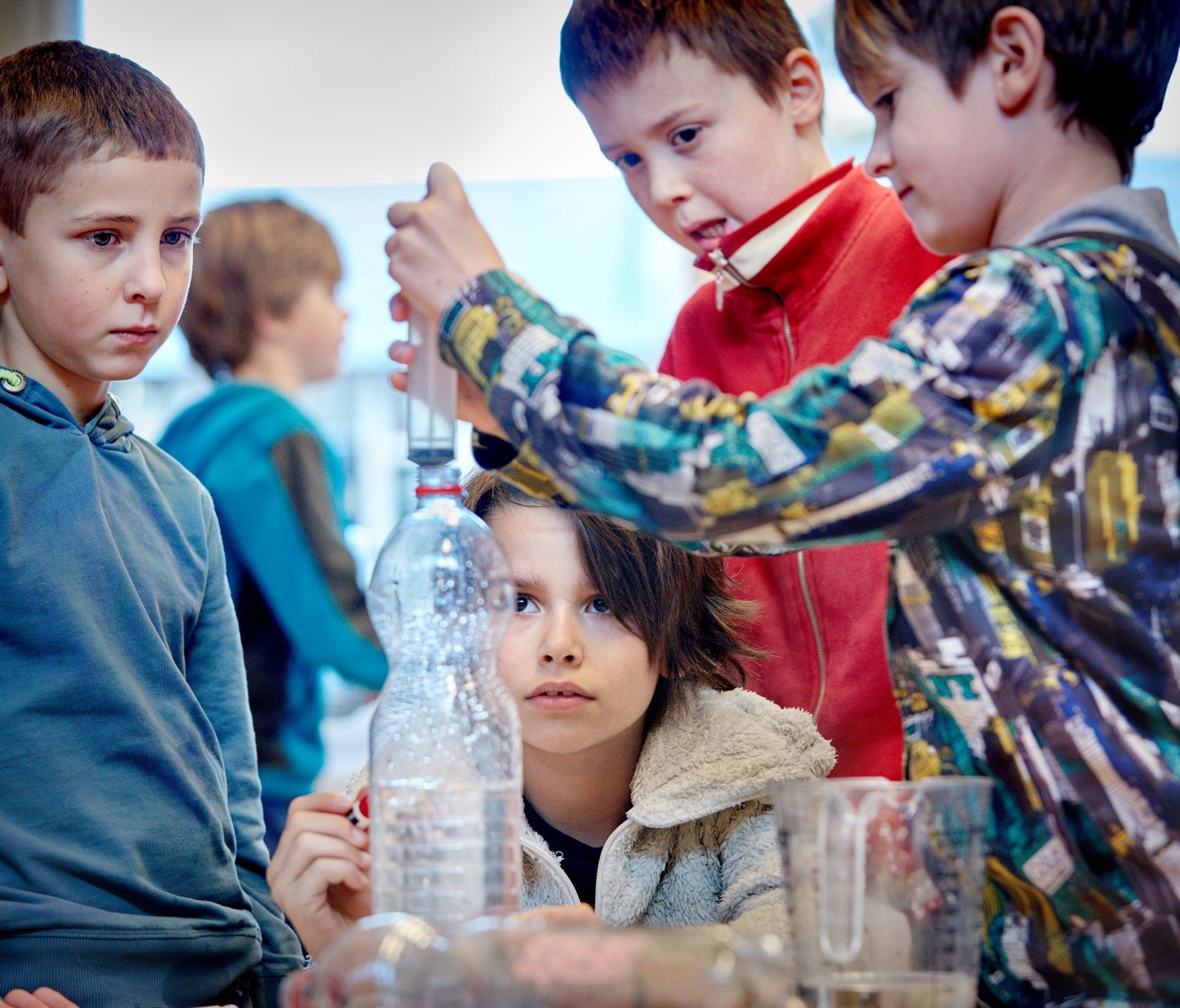 Vier jongens doen water in een fles.