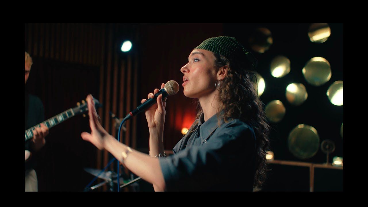 a girl with a bandana singing into a microfone