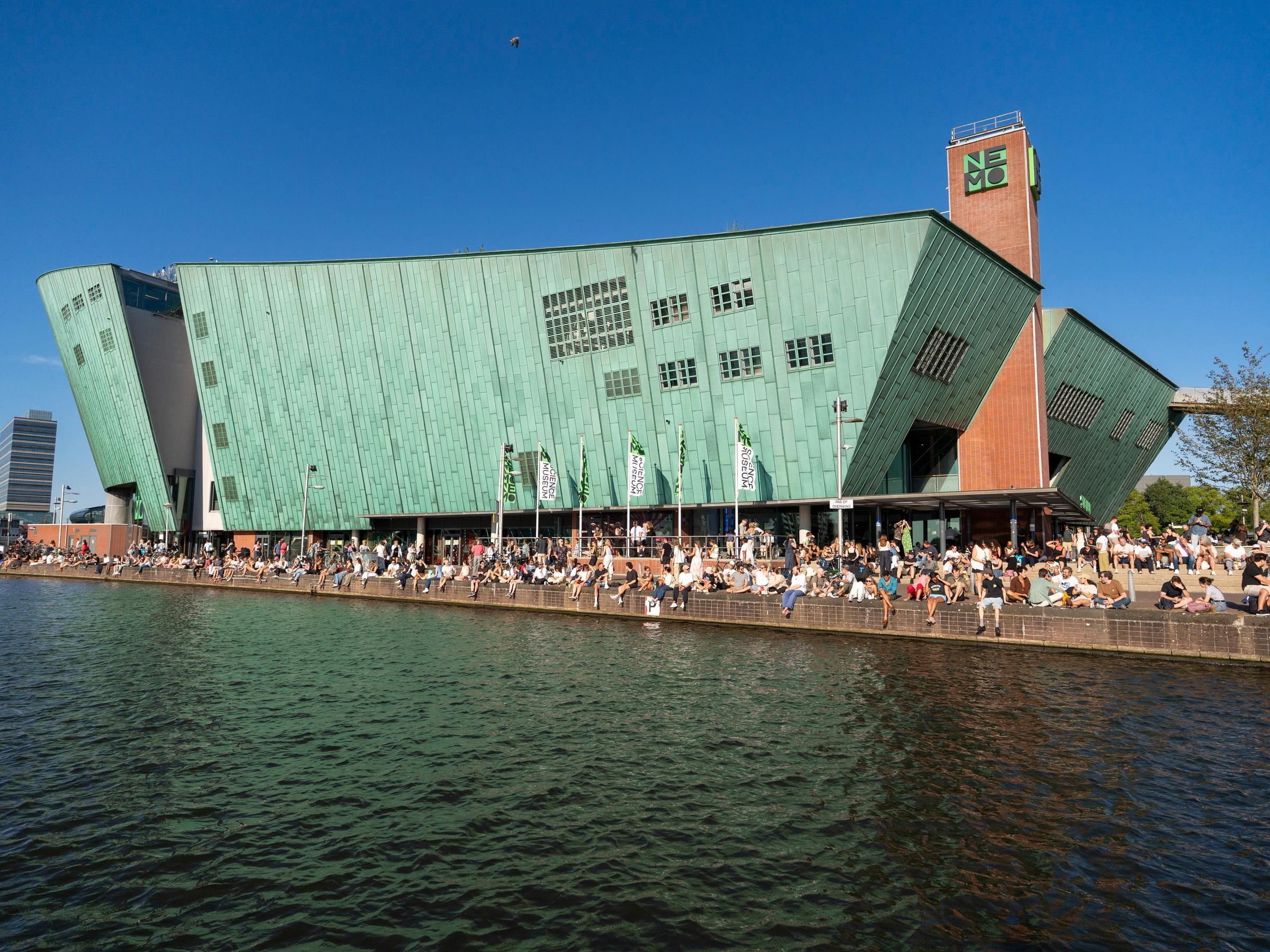 Het gebouw van NEMO met veel mensen ervoor op de kade