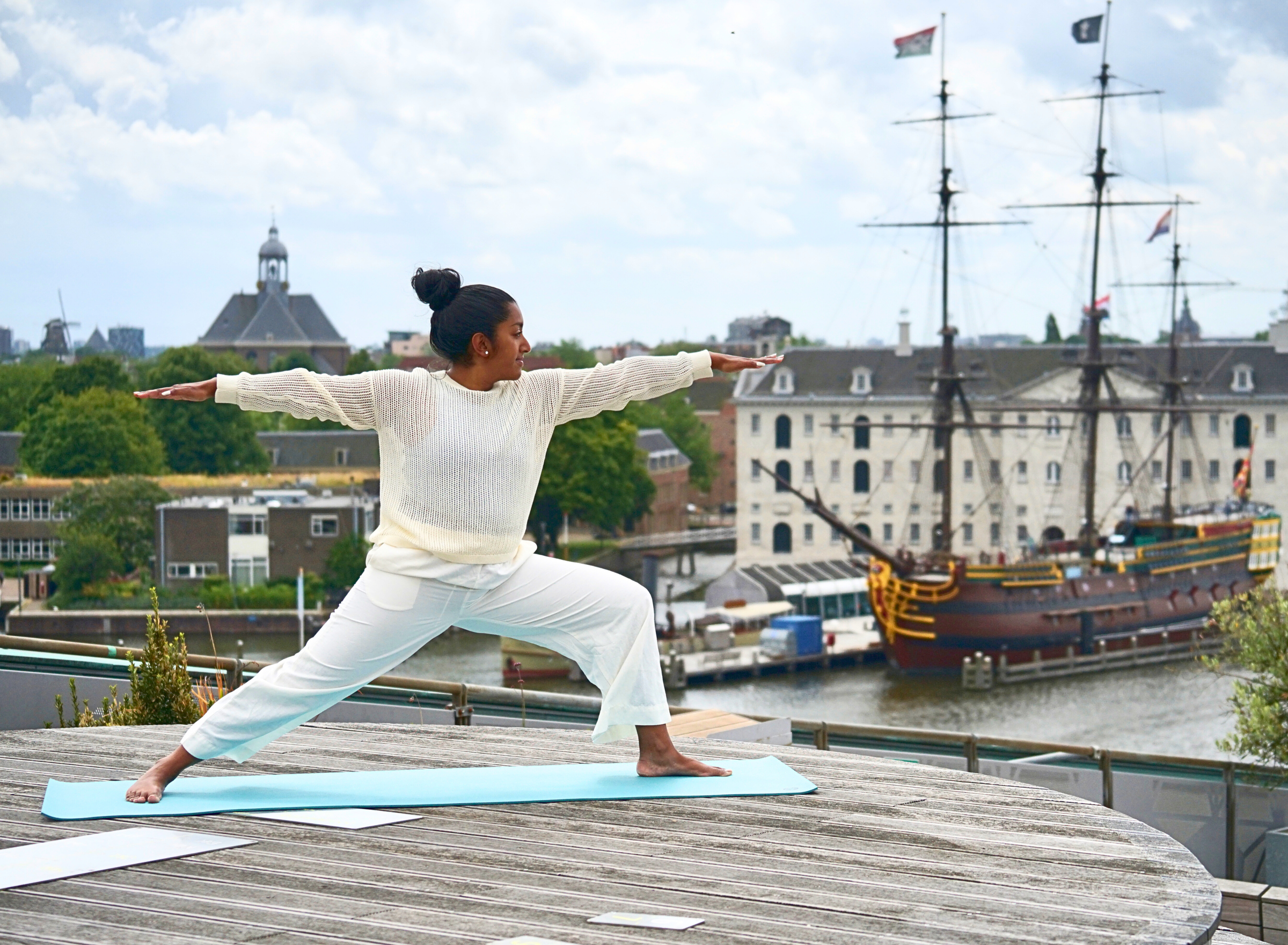 een vrouw doet yoga op het dak van NEMO