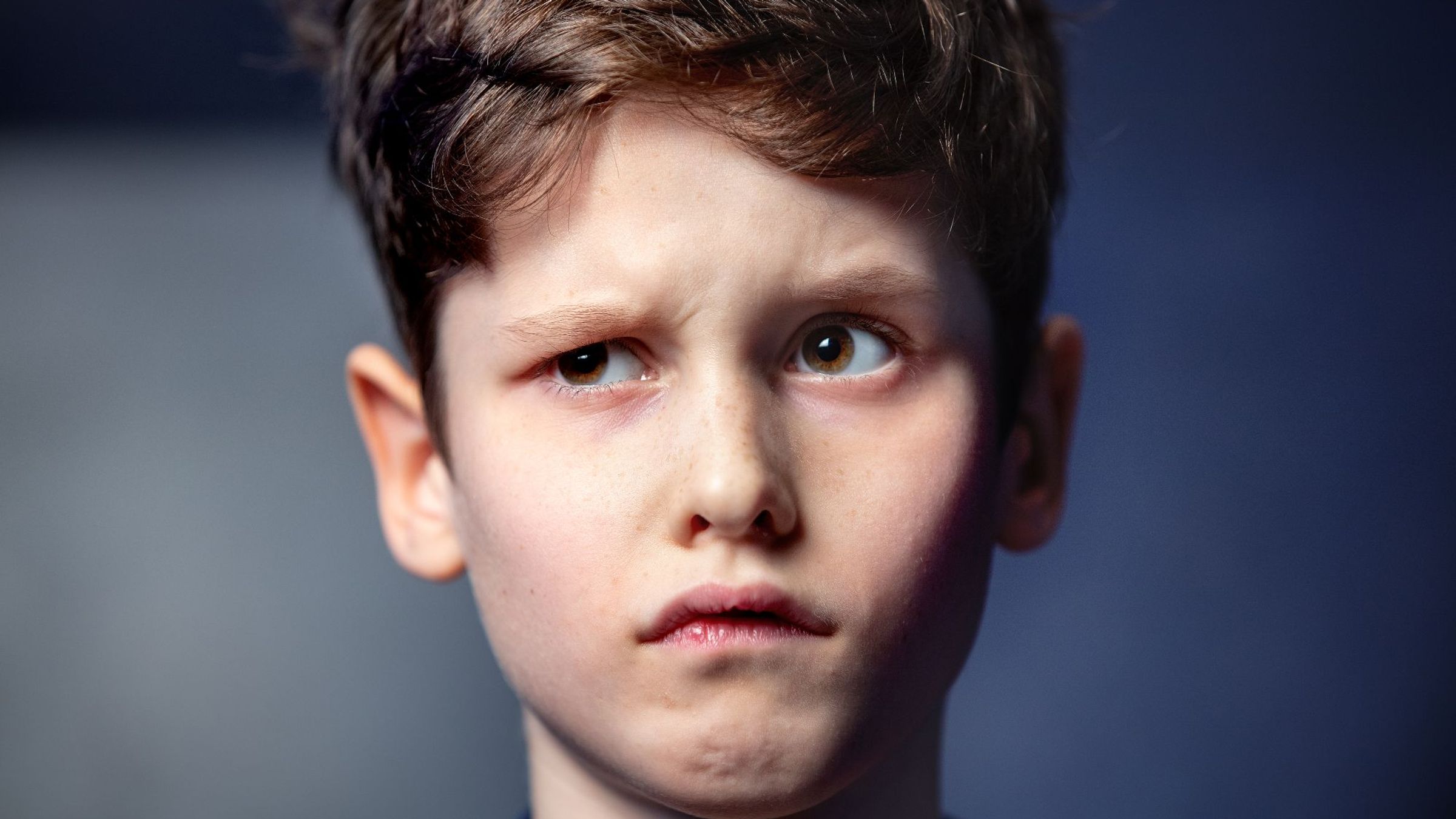 Een jongen met een gefronst gezicht.
